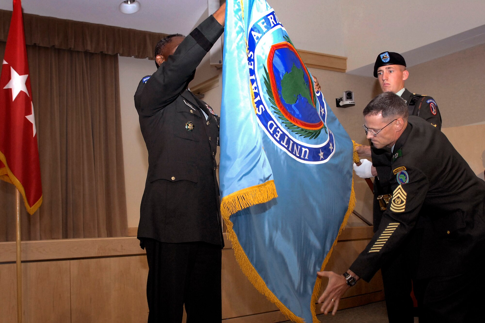 Army Gen. William E. "Kip" Ward (left), commander of the newly activated U.S. Africa Command, and Army Command Sgt. Maj. Mark S. Ripka, AFRICOM command sergeant major, unfurl the command flag during the AFRICOM activation ceremony Oct. 1 in the Pentagon Conference Center.  (Department of Defense photo/Petty Officer 2nd Class Molly A. Burgess)