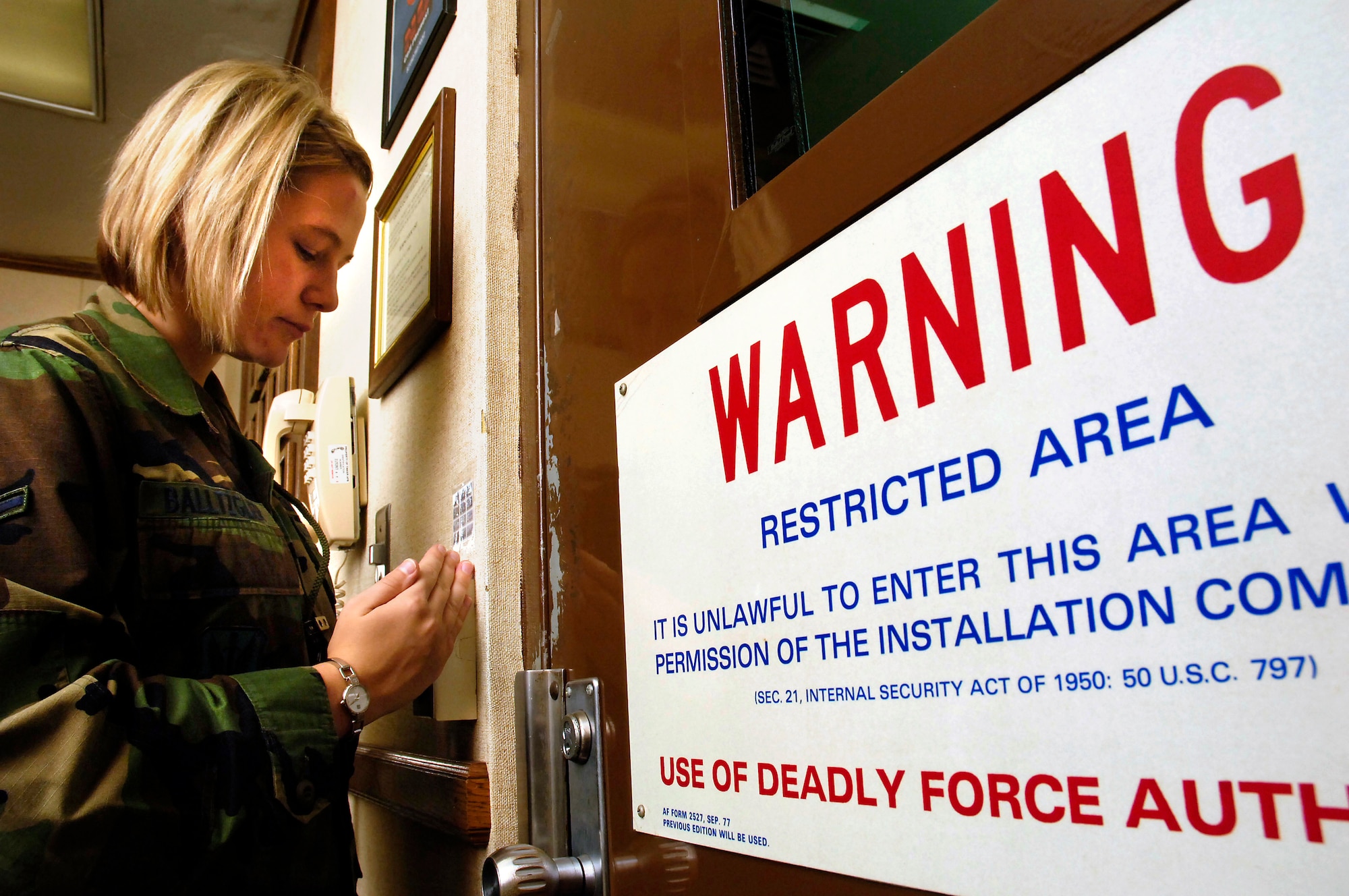 Airman Jessica Balltzglier, junior command post controller at the 552nd Air Control Wing command post, enters her restricted work area where she sits from 6 p.m. to 6 a.m. The command post is an information hub during emergencies or critical situations.(Air Force photo/Dave Faytinger)