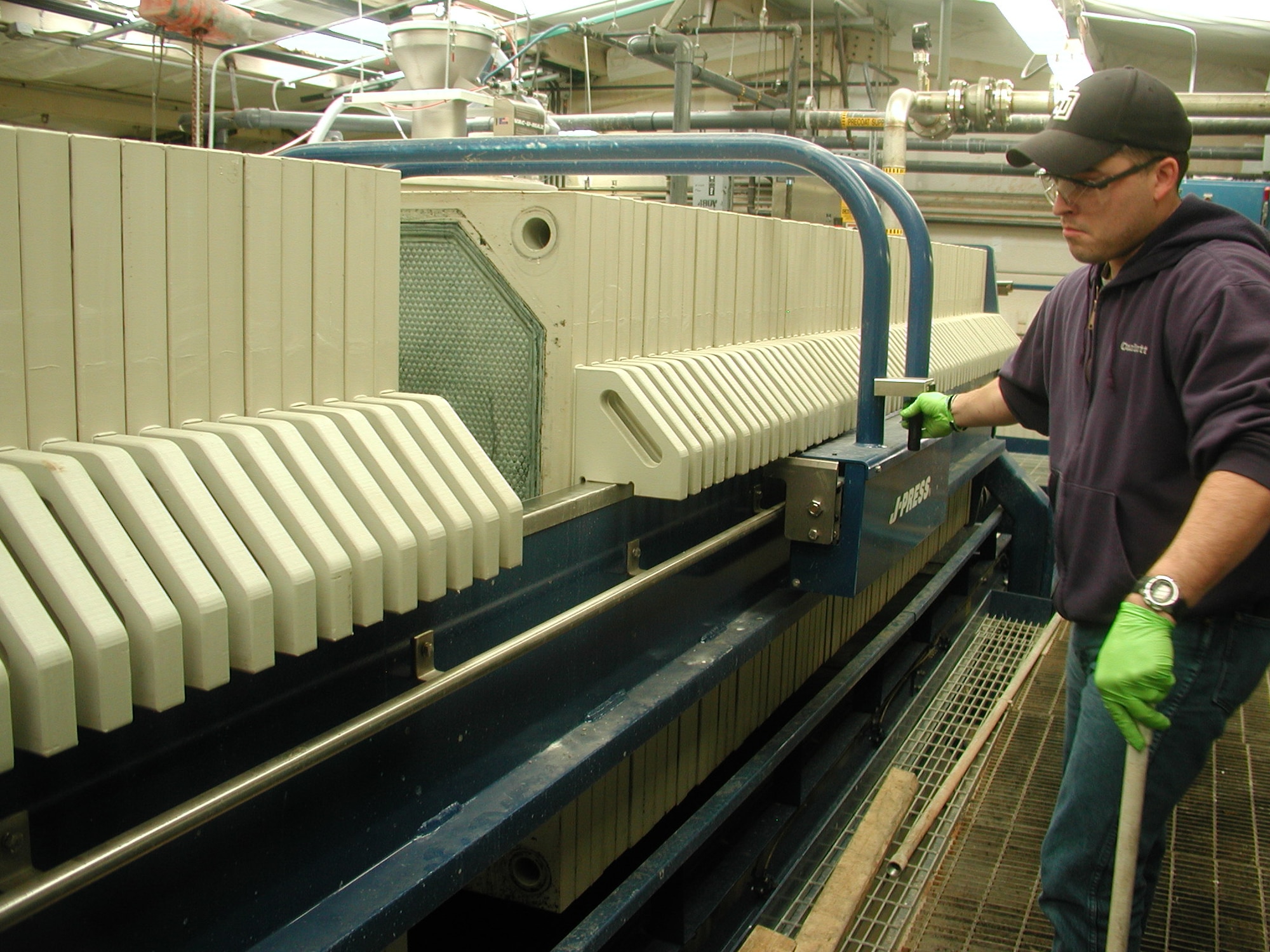 Will Wilson, plant operator, is shown emptying the plate-and-frame filter press at the industrial waste water treatment plant here. A team of 17 people run the plant. Any installation of this size must have a treatment plant. It is a 24/7 operation that processes more than 700,000 gallons of waste water per day. The waste is then discharged to the Oklahoma City Public Works Department. The plate-and-frame press has allowed the installation to make some significant environmental reductions and cost savings by removing most of the water from the hazardous industrial sludge prior to disposal. The IWTP has reduced hazardous waste sludge disposal by 7,079,480 pounds annually, 92 percent, and reduced hazardous waste sludge disposal costs by $1,272,137 annually, 91 percent. (Air Force photo/Freddie Hall)