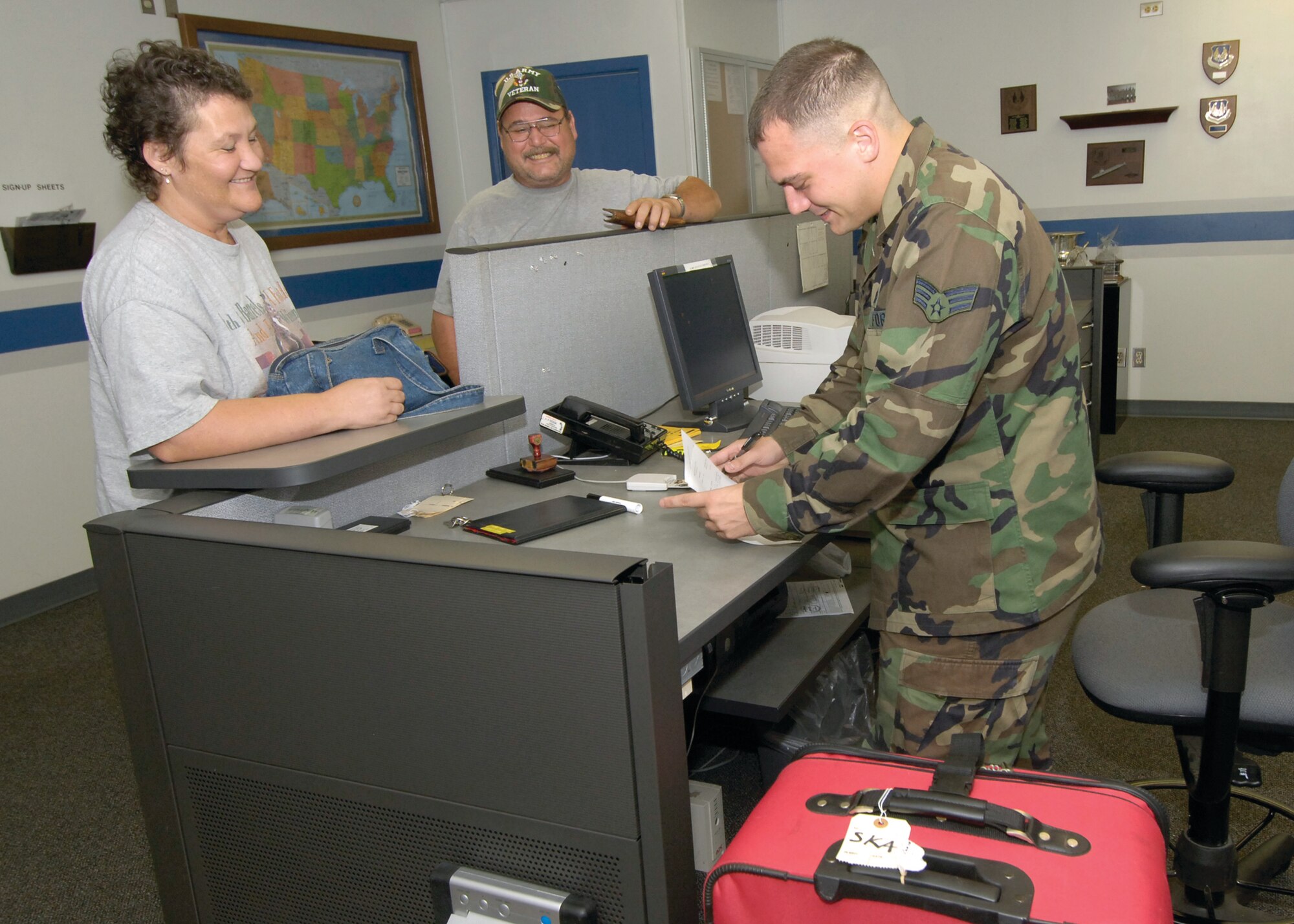 Senior Airman Kenneth Kelley checks in passenger Susan Knowles who is “catching a hop” heading from Tinker to Spokane, Wash., for a family emergency. (Air Force photo/Margo Wright)