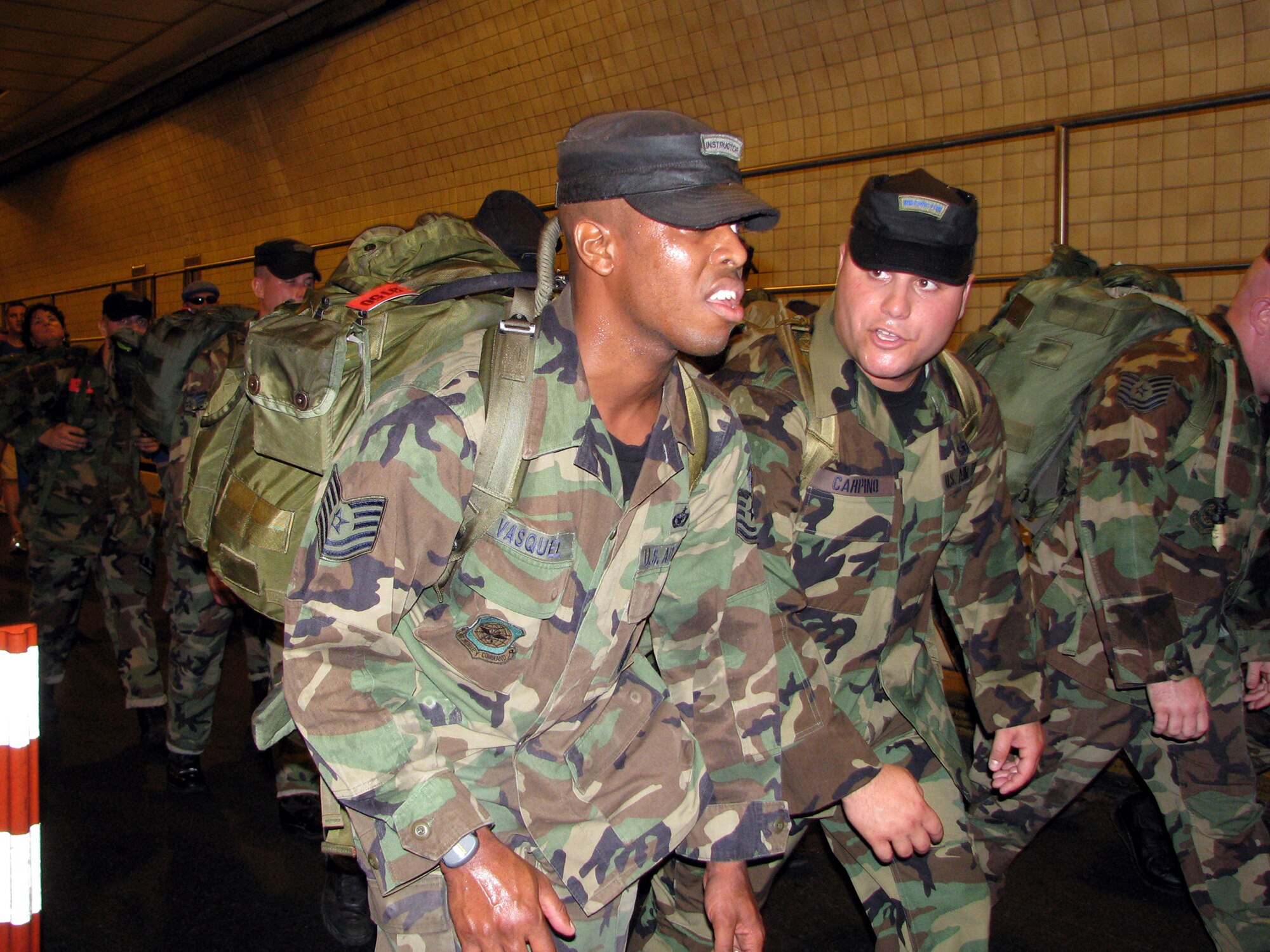 Tech. Sgt. Aubry Vasquez and Staff Sgt. Tommy Carpino discuss which cadence to sing next to continue to motivate the formation and the other participants of the Tunnel to Towers 5-kilometer Run/Walk in New York City Sept. 28, 2008. The Tunnel to Towers is a fundraiser in tribute to Stephen Siller, a New York City firefighter who gave his life on Sept. 11, 2001.  Siller ran from his vehicle in full fire fighter gear from the Brooklyn Battery Tunnel to the World Trade Center when he heard of the disaster over his scanner. Siller had just come off duty and was headed for a round of golf.  (U.S. Air Force Photo/Staff Sgt. Paul R. Evans)