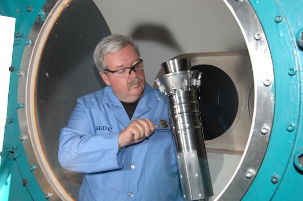 Joe Syler, Aerospace Testing Alliance outside machinist, makes an adjustment to the Ares I first stage booster model in the center’s von Karman Facility’s Tunnel B prior to the resumption of heat transfer testing. (Photo by David Housch)