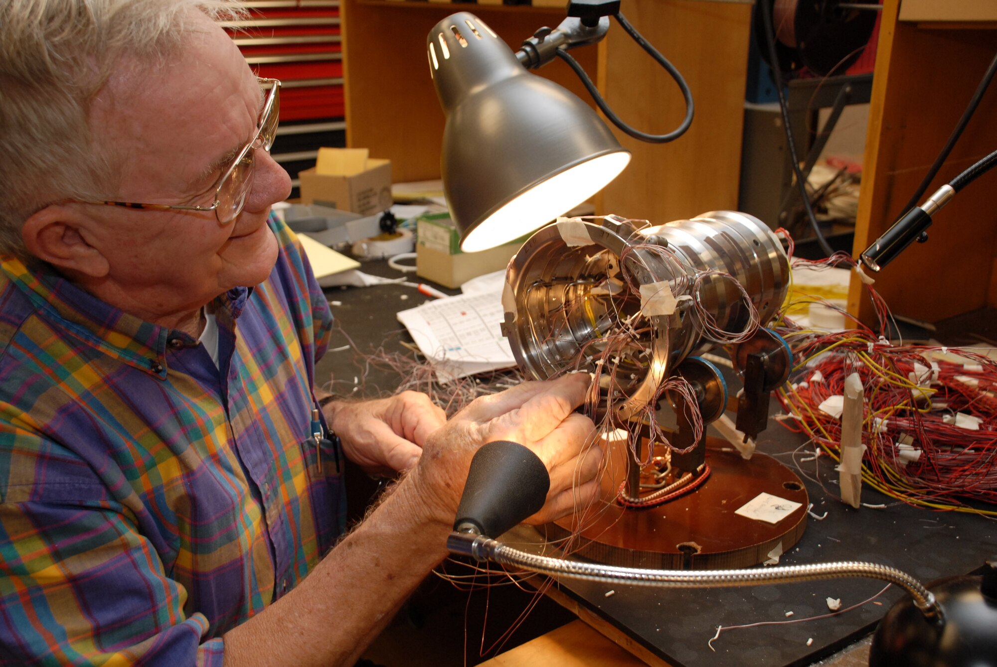 Retired Instrument Technician William Scott ensures the wiring and heat transfer gauges are intact and in place on the scale model of the Ares I first stage booster prior to installation and testing of the component in the center’s von Karman Facility’s tunnels B and C. Scott retired from Sverdrup at AEDC in 1999. With 42 years of professional experience, he has responded to requests for help with a couple of challenging projects at the center's Aerothermal Measurements Lab. (Photo by Rick Goodfriend)