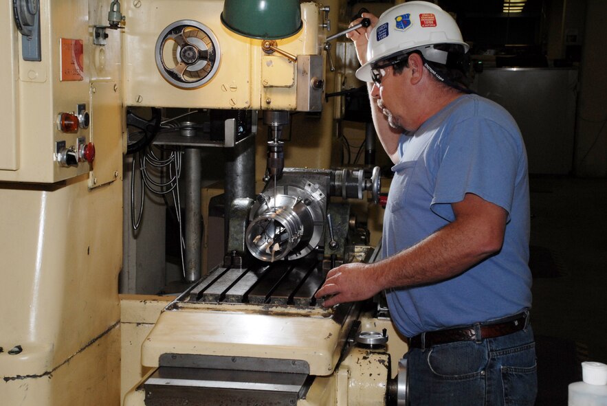 Aerospace Testing Alliance (ATA) Machinist Mickey Cowan, with AEDC’s Model Shop, drills holes in the model of the Ares I first stage booster during the test article’s fabrication phase prior to heat transfer testing. The wires, which are approximately 1/100 of an inch in diameter, are routed from heat transfer gauges on the model through the holes and out 50 feet to the tunnel instrumentation system where the electrical signal (data) is amplified and digitized for collection and analysis.(Photo by Rick Goodfriend)