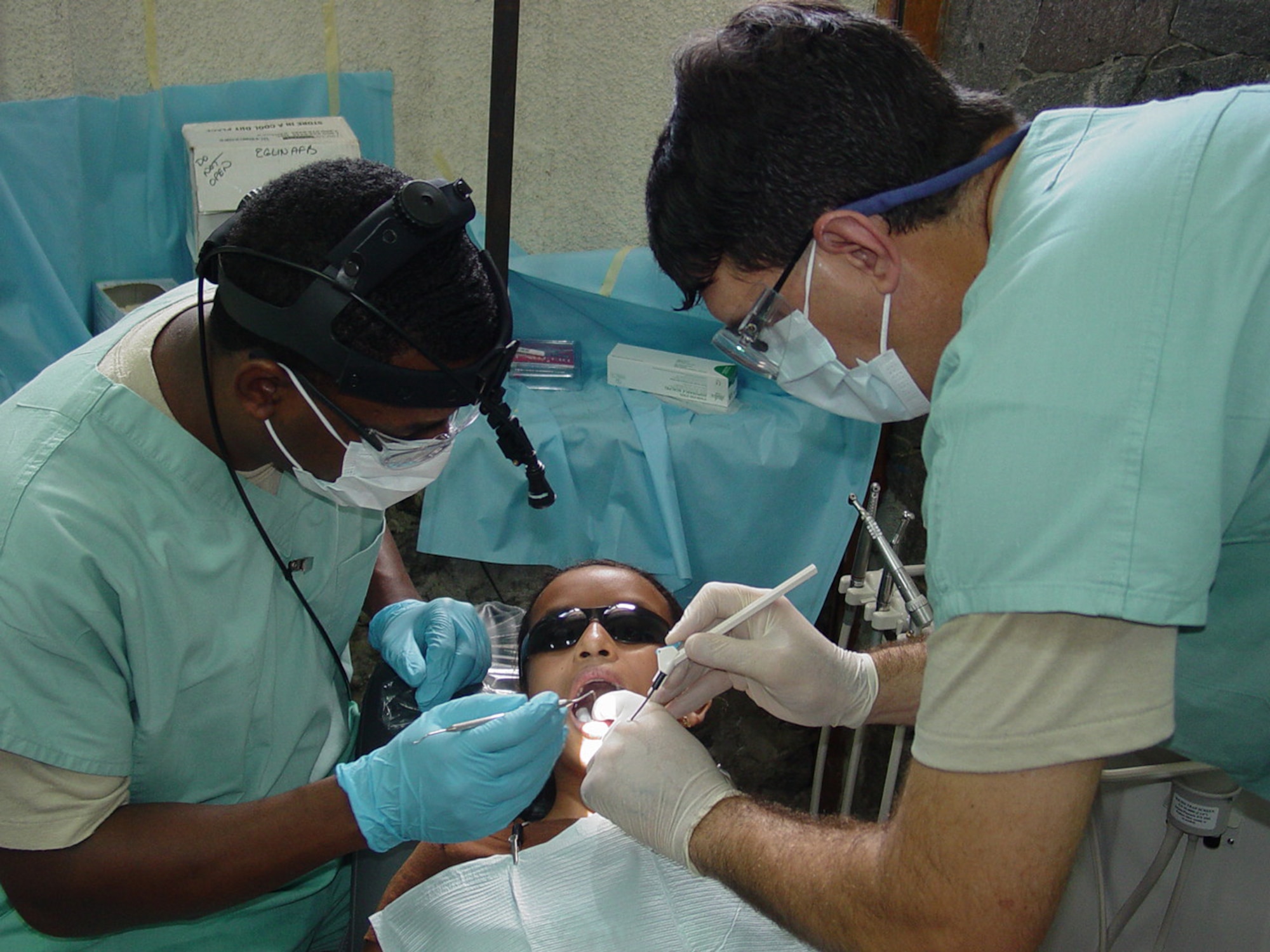 Staff Sgt. Julian Moore, Barksdale AFB, La., places a dental sealant on a patient while Col. (Dr.) Robert Langsten assists. They were two of the eighteen dentists and technicians from Barksdale, Lackland, Langley and Eglin Air Force Bases who supported the first all-dental team readiness exercise in Zacatecoluca, El Salvador Sept. 6-20. (courtesy photo)                             