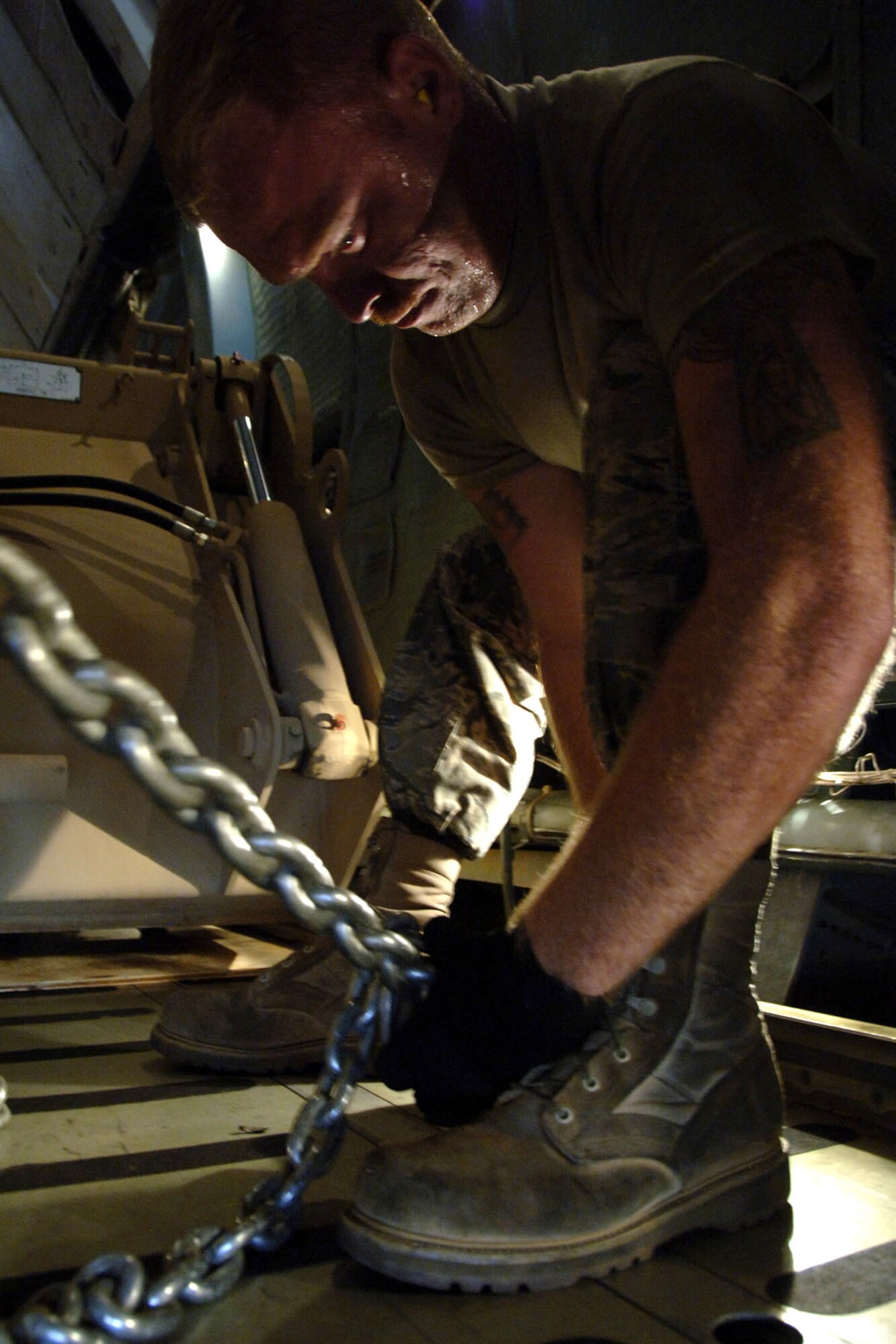 Senior Airman Jared Parsons tightens a clamp to secure an Army High Mobility Engineer Excavator to the bed of a C-5 Galaxy before takeoff Sept. 29 at Charleston Air Force Base, S.C. The HMEEs will be transported to forward deployed locations to assist Soldiers and contractors in hostile environments. Airman Parsons is an air transportation journeyman with the 437th Aerial Port Squadron. (U.S. Air Force photo/Airman 1st Class Timothy Taylor)
