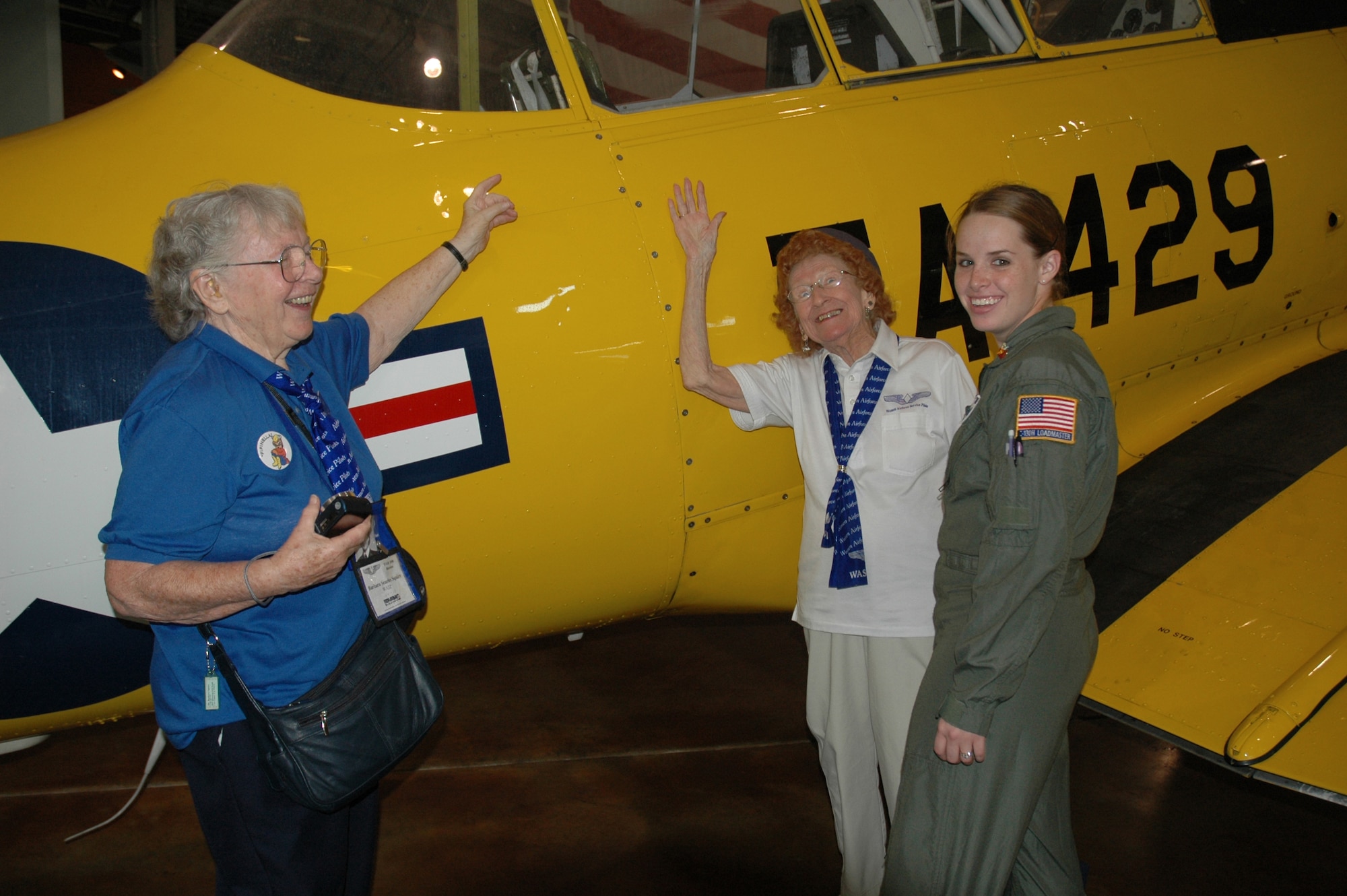 Former WASP members, Barbara Squires, left, and R. Betty "Wall" Strohfus discuss the attributes of a T-6 Texan with Air Force Reservist Senior Airman Leigha Samples, a C-130 Hercules loadmaster with Maxwell AFB, Ala.'s 357th Airlift Squadron, 908th Airlift Wing. (U.S. Air Force Photo by Staff Sgt. Jay Ponder