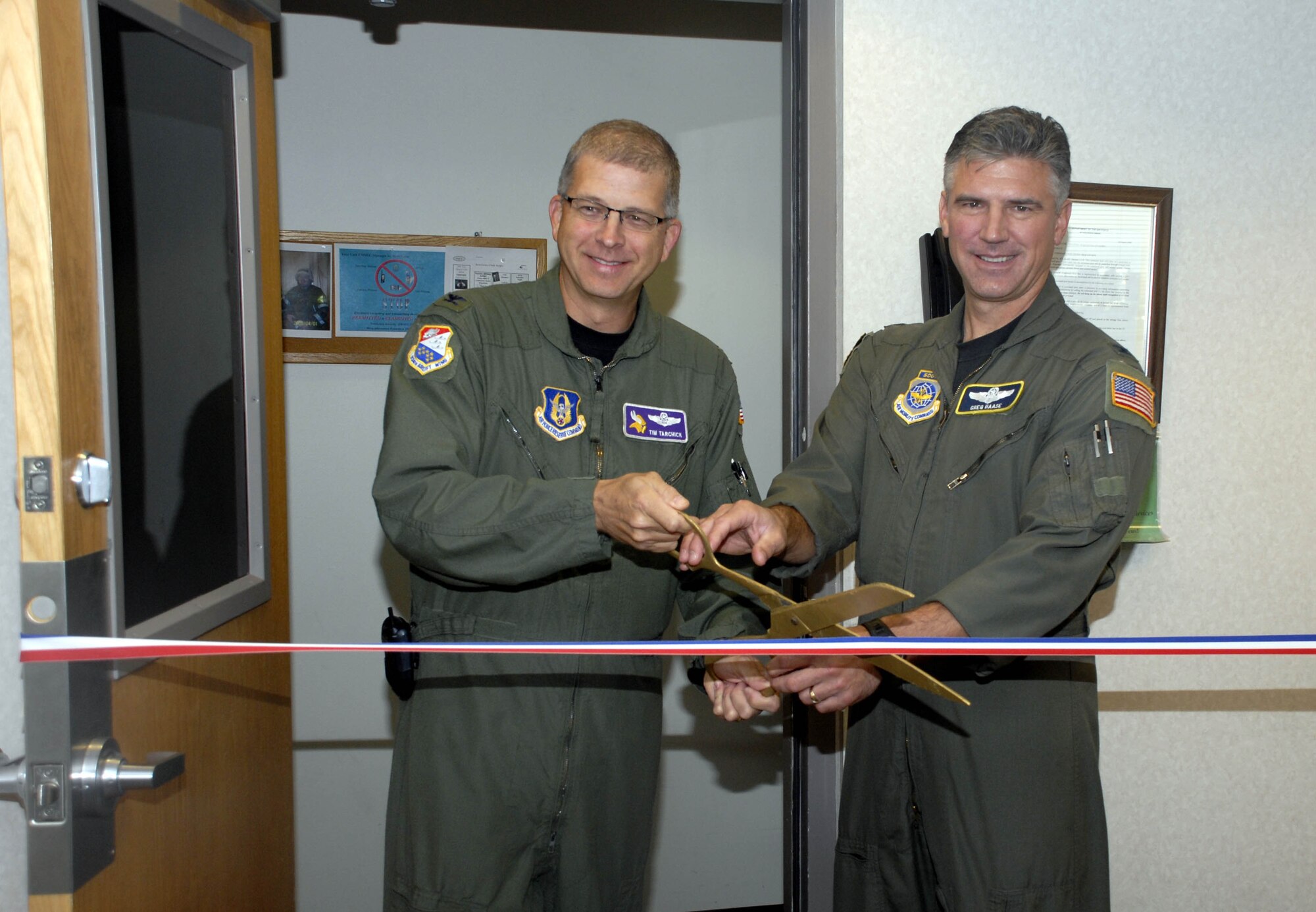 Col. Tim Tarchick, 934th Airlift Wing commander (left) and Col. Greg Hasse, 133rd Airlift Wing commander, cut the ceremonial ribbon for the new Joint  Command Post. (Air Force Photo/Master Sgt. Paul Zadach)