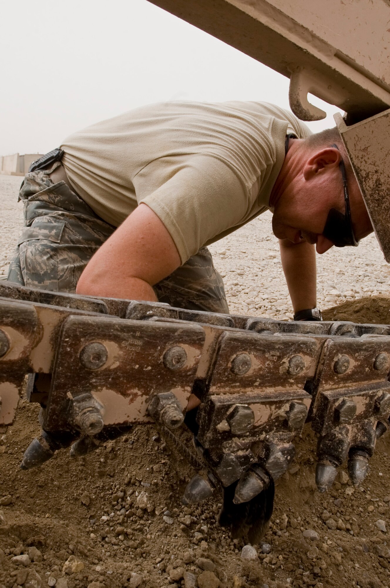 ALI BASE, Iraq -- Staff Sgt. Dustin Bray, 407th Expeditionary Civil Engineer Squadron Utilities Shop, moves a metal cable out of the way to avoid damaging the equipment Oct. 1, 2008 Utilities shop Airmen are preparing the phase three build up site, which will contain trailers, the base will eventually be given back to the Iraqi military and left in better condition.  Bray is deployed from F.E. Warren Air Force Base, Wyo. (U.S. Air 
Force photo/Airman 1st Class Christopher Griffin)


