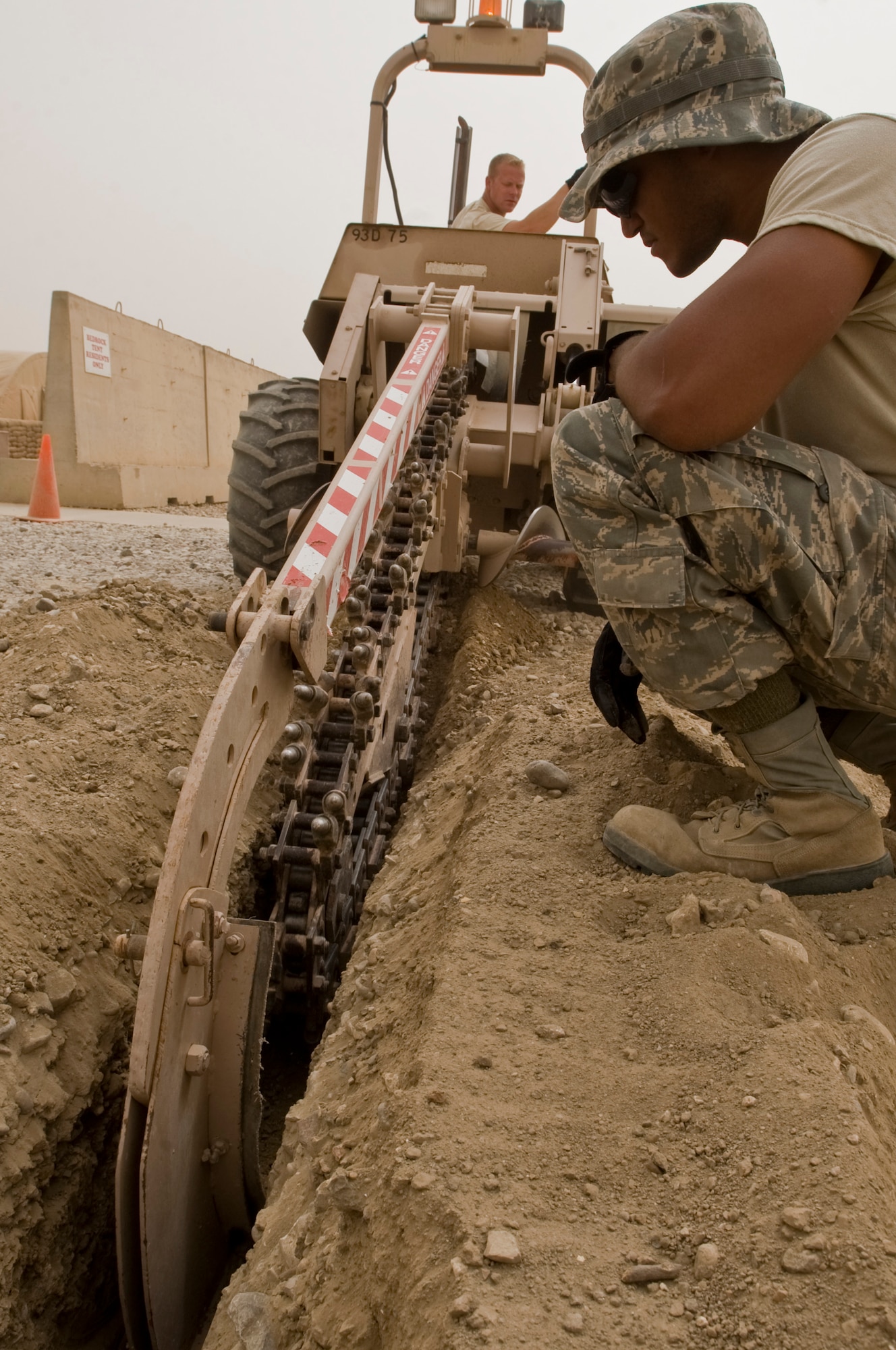 ALI BASE, Iraq -- Airman 1st Class Aaron Weathers guides Staff Sgt. Justin Teuscher, 407th Expeditionary Civil Engineer Squadron Utilities Shop, while plowing for a potential water pipe route Oct. 1, 2008. Utilities shop Airmen are preparing the phase three build up site, which will contain trailers, the base will eventually be given back to the Iraqi military and left in better condition. Weathers and Teuscher are deployed from F.E. Warren Air Force Base, Wyo. (U.S. Air Force photo/Airman 1st Class Christopher Griffin)