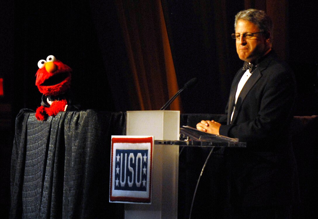 Sesame Street star Elmo shares his ideas for how he could help the United Service Organizations with Gary Knell, Sesame Workshop president. The two addressed the crowd gathered for the 2008 USO World Gala in Washington on Oct. 1, 2008, to let them know about Sesame Workshop's partnership with USO. The program "The Sesame Street Experience," is a free, traveling tour for military families. It's part of the Workshop's "Talk, Listen, Connect," program that helps military families handle the stresses of military life. DoD photo by Samantha L. Quigley