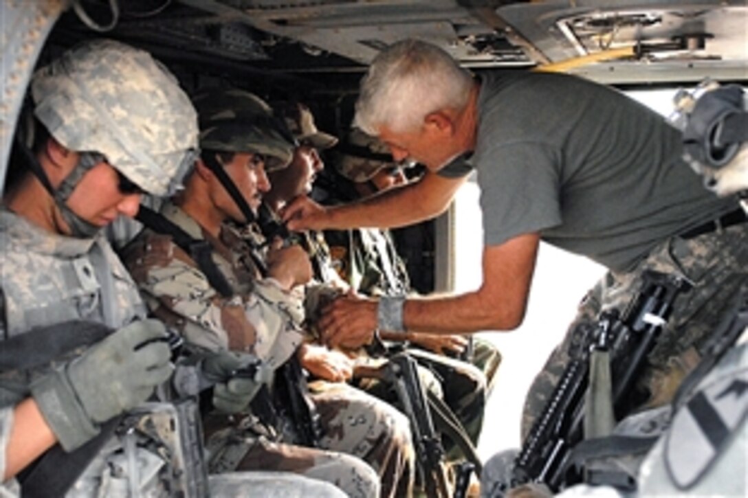 U.S. Army Sgt. Larry Metscher, a crew chief assists an Iraqi soldier in fastening his seat restraint in a UH-60 Black Hawk helicopter on Forward Operating Base Garry Owen, Iraq, Sept. 25, 2008. Metscher is assigned to the 4th Brigade Combat Team, 1st Cavalry Division, and believes that the Iraqi soldiers did exceptionally well during their landing zone training with the Long Knife soldiers. 