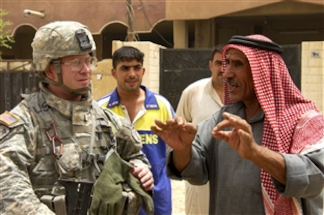 U.S. Army Maj. Ben Hastings speaks with a local national during a humanitarian mission in Haqim, Iraq, Sept. 20, 2008. Hastings is attached to the 12th Cavalry Regiment, 2nd Brigade Combat Team, 1st Cavalry Division.