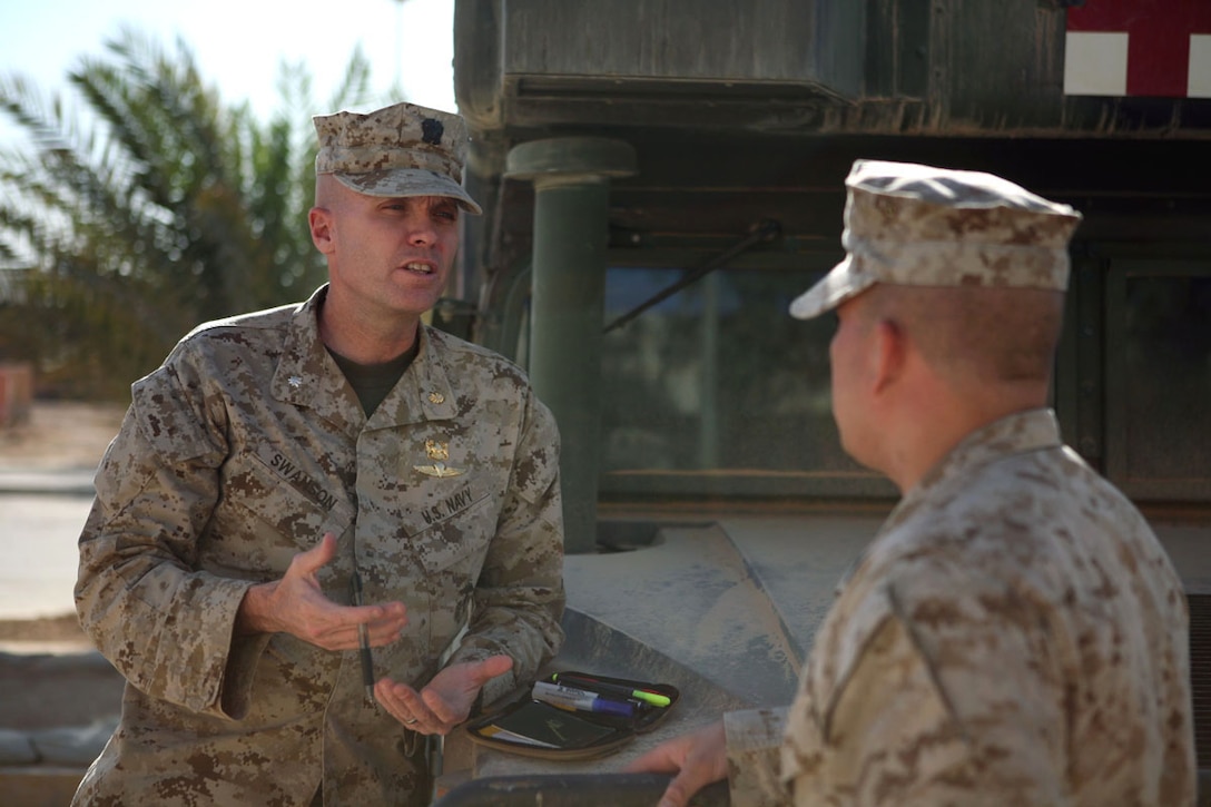 Cmdr. Michael G. Swanson, regimental surgeon, Regimental Combat Team 5, explains what he would like to do at the next cooperative medical engagement to Petty Officer 2nd Class Michael G. Bundeson, assistant leading petty office, regimental aid station, RCT-5, Oct. 2 at Camp Ripper, Iraq. Swanson has had a hand in many projects for RCT-5 such as developing rural health engagements and planning improvements to the hospital in Haditha.::r::::n::