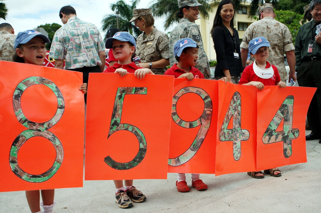 Children from the Navy Hale Keiki School display their Combined Federal Campaign charity code during the Hawaii - Pacific Area CFC kickoff in front of the U.S. Pacific Command Building Oct. 3. The children were in attendance to bring potential donors' awareness to their school, which boasts a 90 percent military-dependents rate.