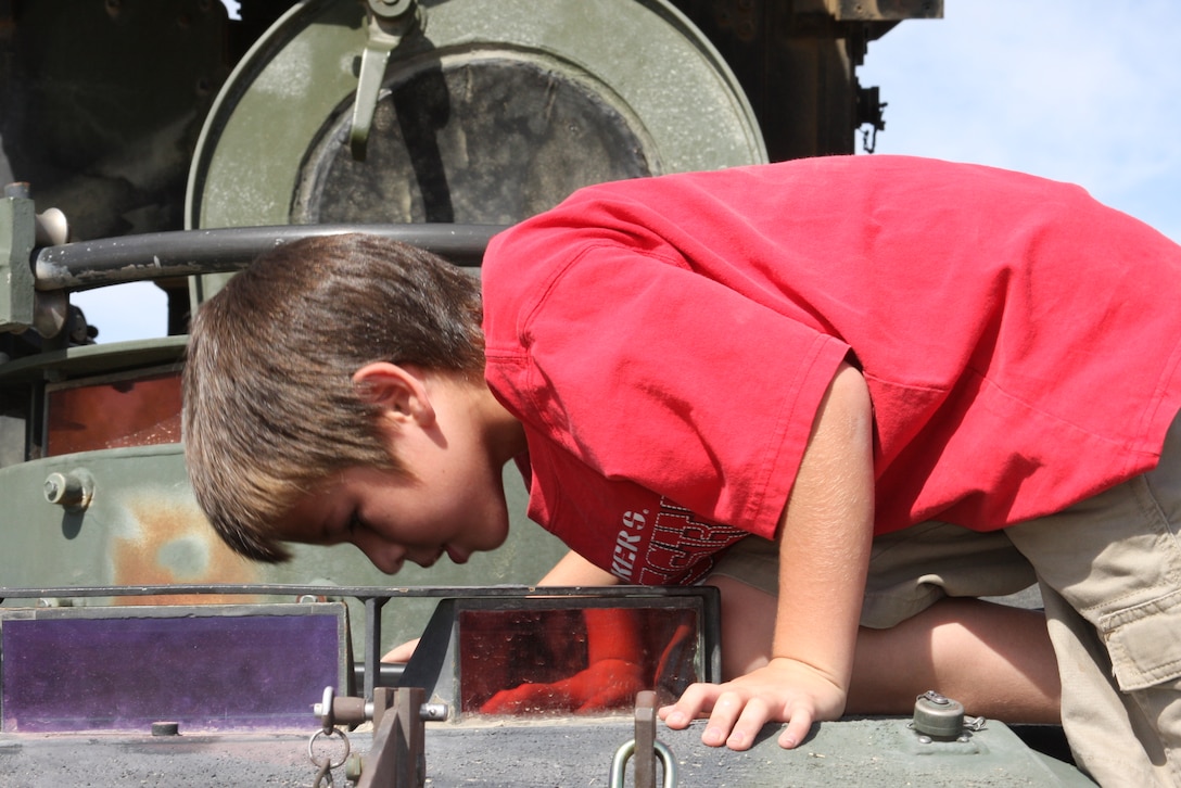 Zack Nelson, a second-grader at Palm Vista Elementary School in Twentynine Palms, Calif., peers down the assistant driver’s hatch during the Wearable Power Prize competition technology showcase and kid’s day at Del Valle Field Friday.