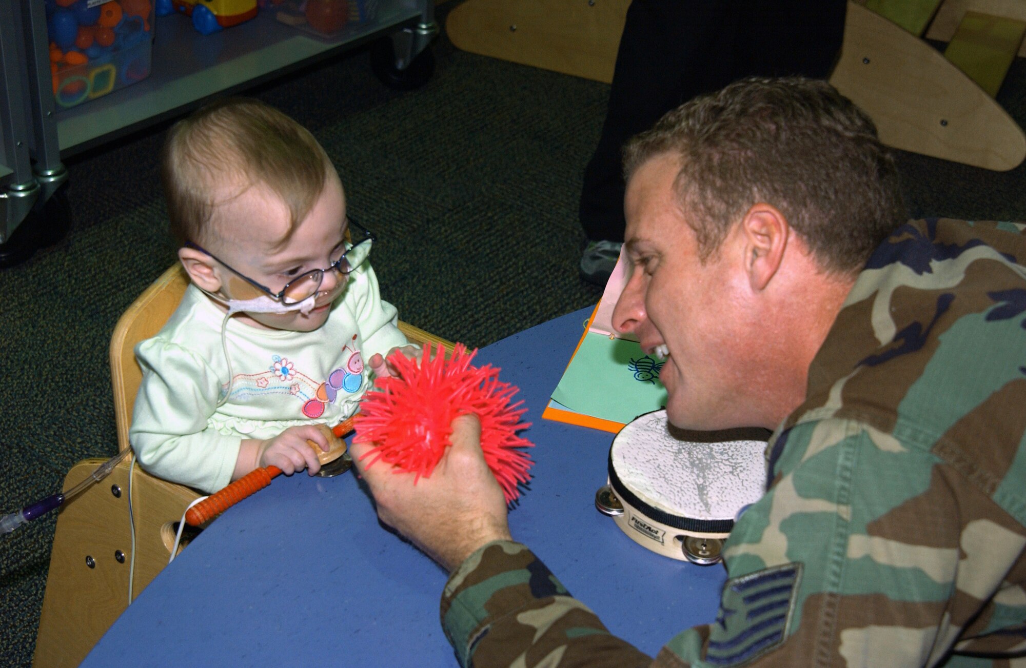 Tech. Sgt. David French entertains Dilana, a patient at a pediatrics specialty hospital in St. Louis, Mo., during an Airmen for Children visit.  Sergeant French has volunteered periodically to spend time with children staying at the hospital.  He is the client support NCOIC for the 375th Communications Squadron at Scott Air Force Base, Ill.  (U.S. Air force Photo/Airman 1st Class Amber Kelly-Woodward)