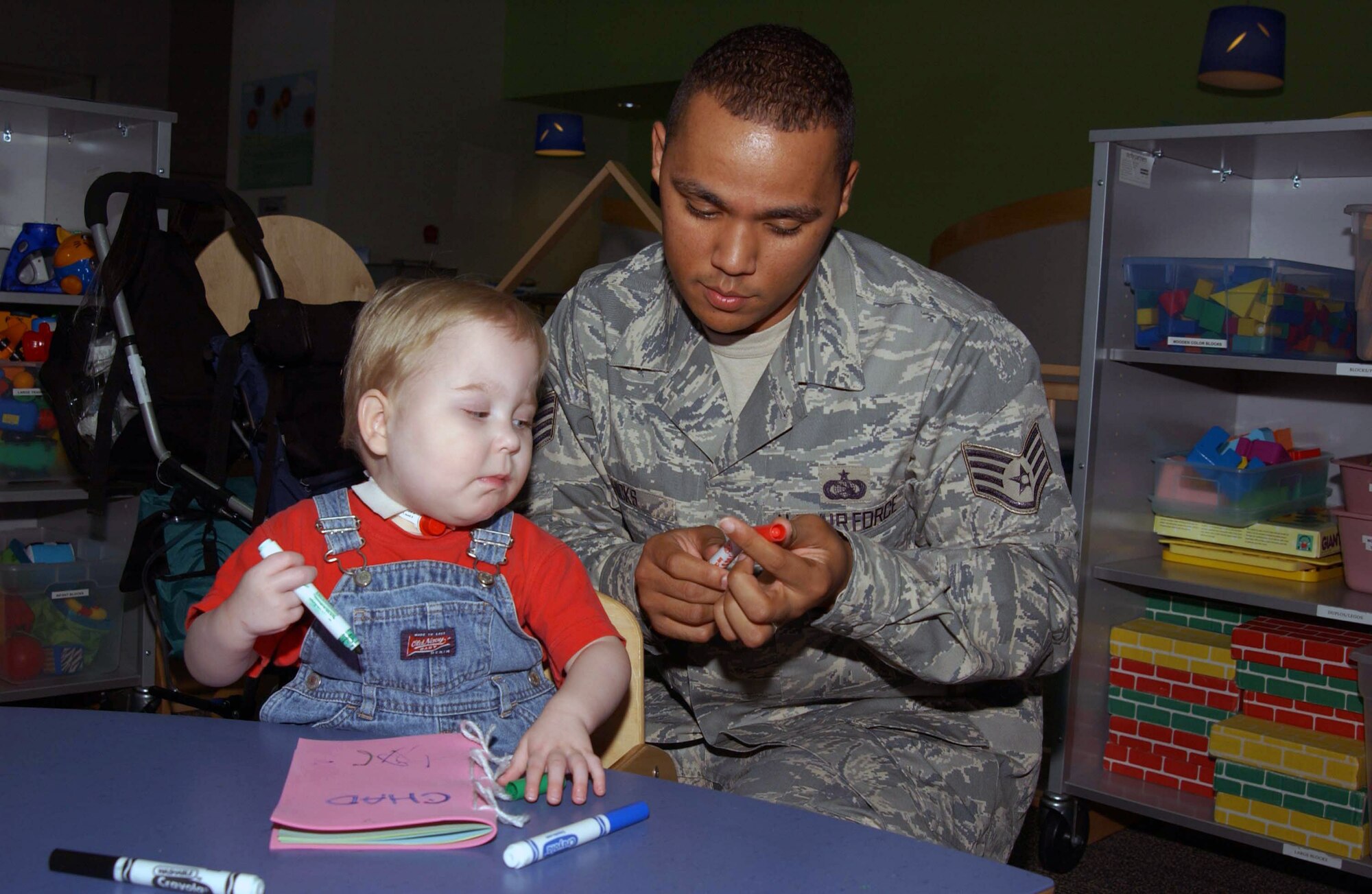 Staff Sgt. Jewell Hicks Jr. helps Chad, a patient at a pediatrics specialty hospital in St. Louis, Mo., create a book about what motivates him during an Airmen for Children visit. Sergeant Hicks began Airmen for Children, a volunteer project that enables Airmen from nearby Scott Air Force Base, Ill., to spend time with children at the hospital. During the visit, Airmen playing with the children add non-medicinal healing to the children's stay in the hospital.  Sergeant Hicks is an executive communications support Airman with the 375th Communications Squadron at Scott AFB.  (U.S. Air force Photo/Airman 1st Class Amber Kelly-Woodward) 
