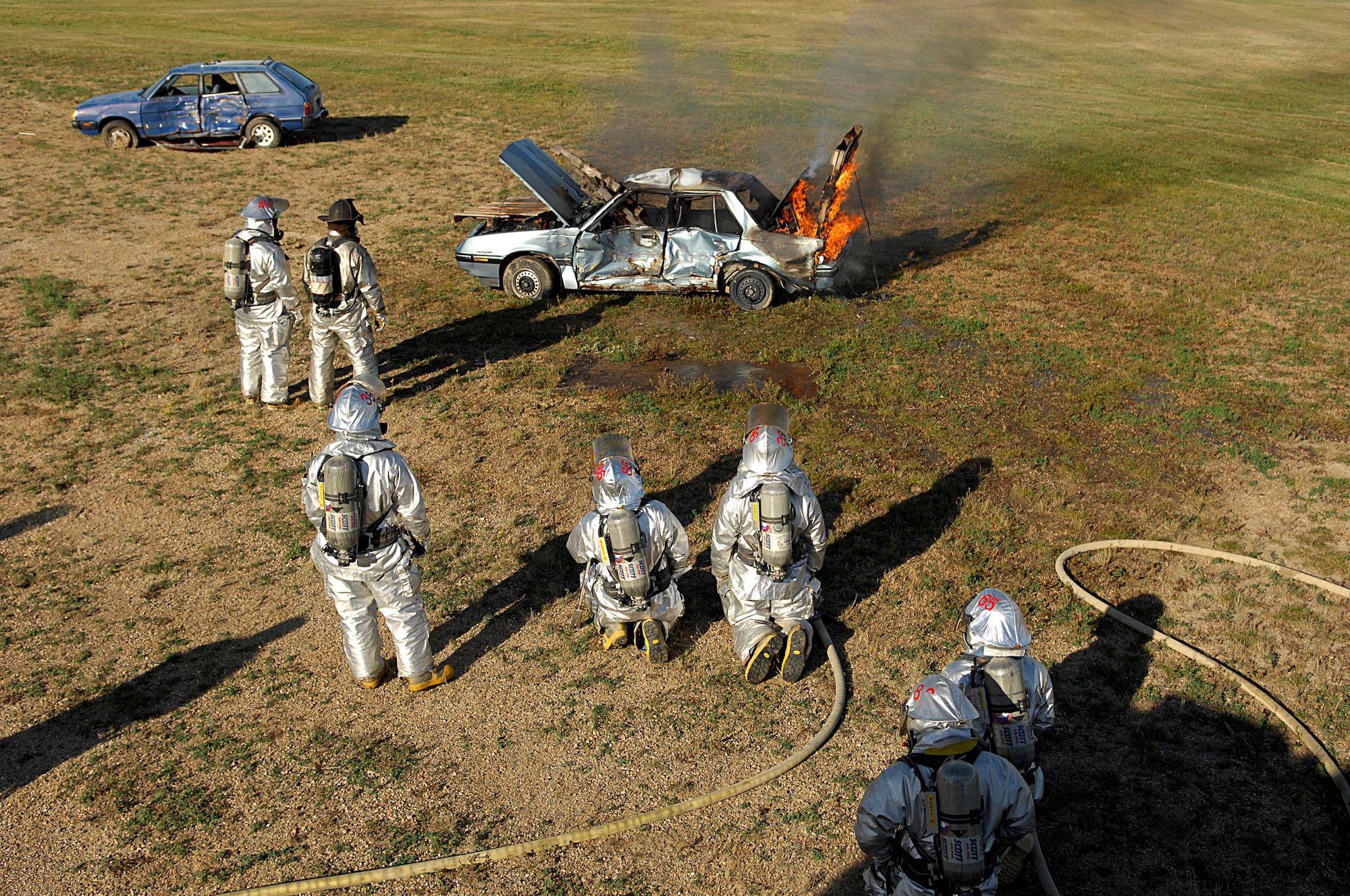 MINOT AIR FORCE BASE, N.D. -- Fire Fighters from the 5th Civil Engineer Squadron here wait for a donated car to become fully engulfed in fire as part of their semi-annual automobile fire extinguishing training, Oct.1.  A local scrap-metal company donated the car to assist the base fire department with maintaining their currency for this requirement. (U.S. Air Force photo by Senior Airman Kelly Timney)