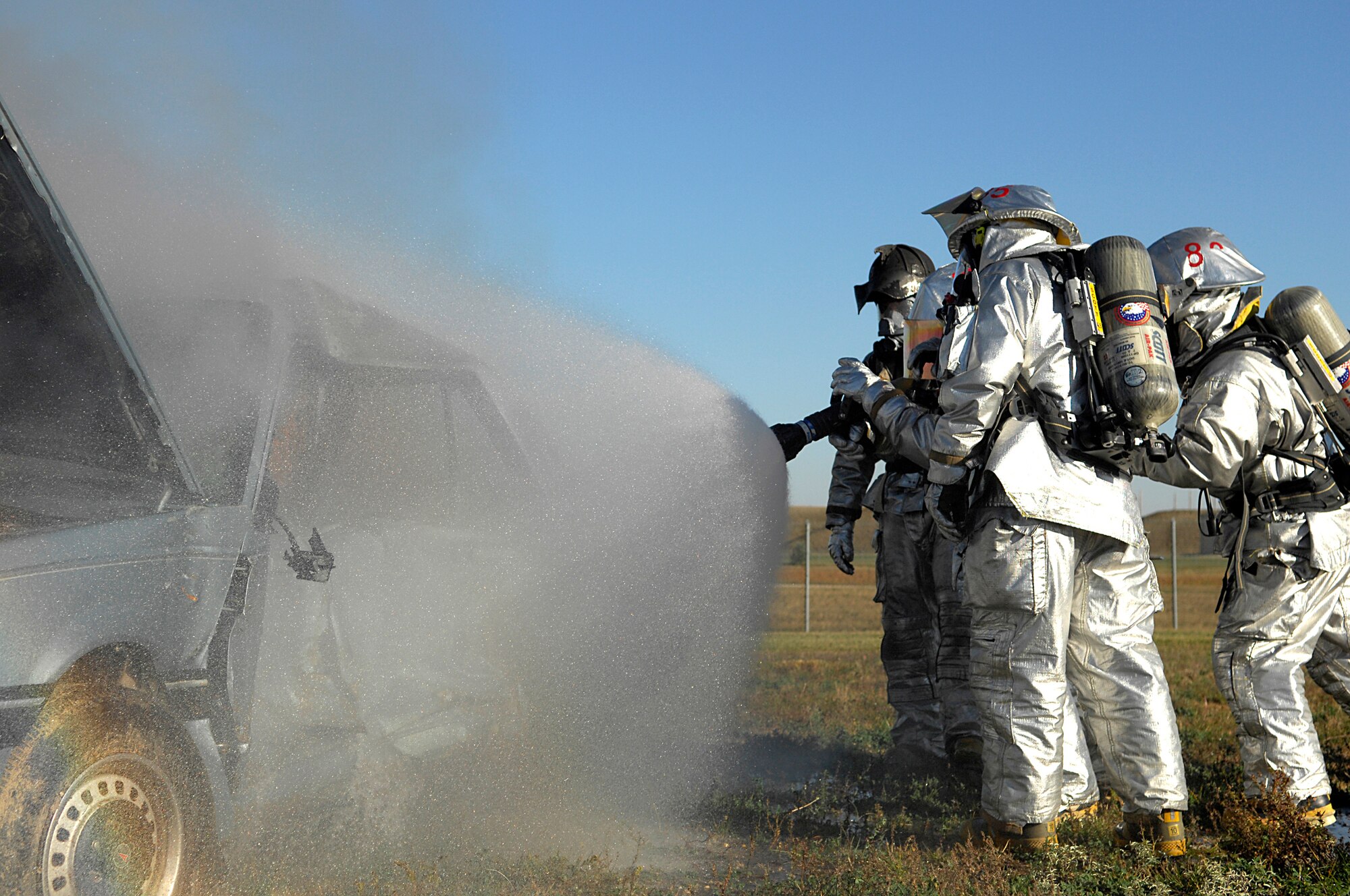 MINOT AIR FORCE BASE, N.D. -- Fire Fighters from the 5th Civil Engineer Squadron here extinguish a burning car during a live fire training exercise as part of their semi-annual automobile fire extinguishing training, Oct.1.  A local scrap-metal company donated the car to assist the base fire department with maintaining their currency for this requirement. (U.S. Air Force photo by Senior Airman Kelly Timney)