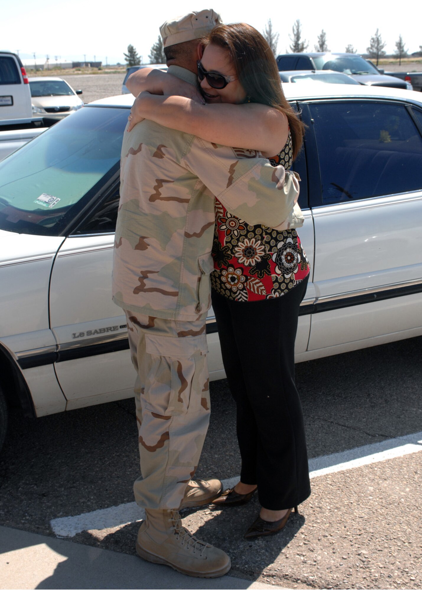 Staff Sgt. David Aguirre, 49th Aircraft Maintenance Squadron, hugs wife Cristina Aguirre, upon his arrival to Holloman Air Force Base, N.M., October 1. Sergeant Aguirre worked as a vehicle control non comissioned officer during his four month deployment to Al Udeid, Qatar. (U.S. Air Force photo/Airman 1st Class Veronica Salgado)  
