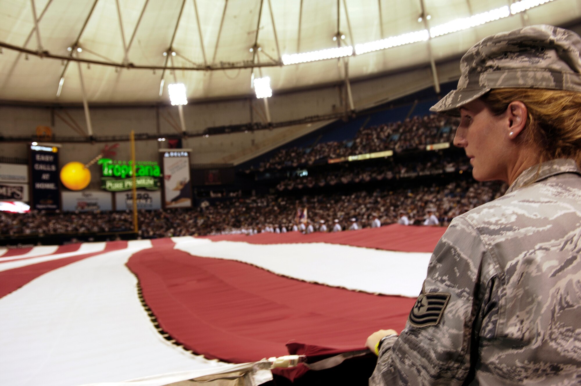 Tech. Sgt. Duska Rowe, 6th Medical Operations Squadron, holds the American Flag along members of the U.S. Coast Guard assigned to sector St. Petersburg, Fla., and other 6th Air Mobility Wing Airmen, while the National Anthem plays during the Tampa Bay Ray's American Division League Series playoff game against the Chicago White Sox Oct. 2. The Rays invited all military members who participated in the ceremony to stay and watch the Ray?s first ever playoff game in franchise history. MacDill Air Force Base and the Tampa Bay Ray?s have both formed a great community involvement relationship since the team?s creation in 1998.  The Ray?s, the American League East Champions, beat the Chicago White Sox six to four in game one of the best-of-five playoff series.  (Air Force photo by Tech Sgt Sean Mateo White)
