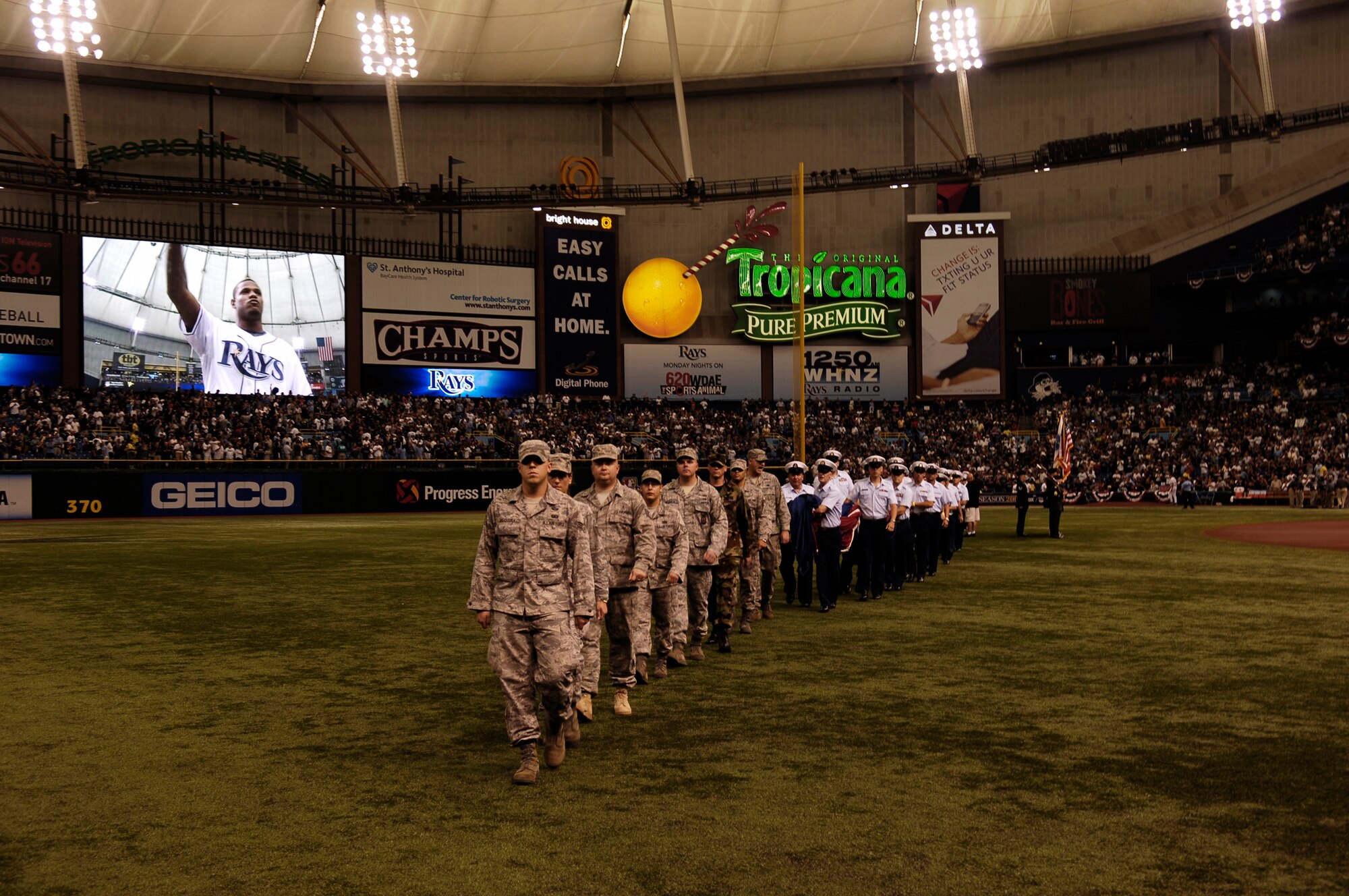 Airman from the 6th Air Mobility Wing teamed with members of the U.S. Coast Guard assigned to sector St. Petersburg, Fla.,  for the presentation of the American flag at Tropicana Field during the Tampa Bay Ray's American Division League playoff game against the Chicago White Sox Oct. 2. The Rays invited all military member who participated in the ceremony to stay and watch the Ray?s first ever play-off game in franchise history.  MacDill and the Tampa Bay Ray?s have both formed a great community involvement relationship since the team?s creation in 1998.  The Ray?s, the American League East Champions, beat the Chicago White Sox six to four in game one of the best-of-five playoff series.  (Air Force Photo by Tech. Sgt. Sean Mateo White)
