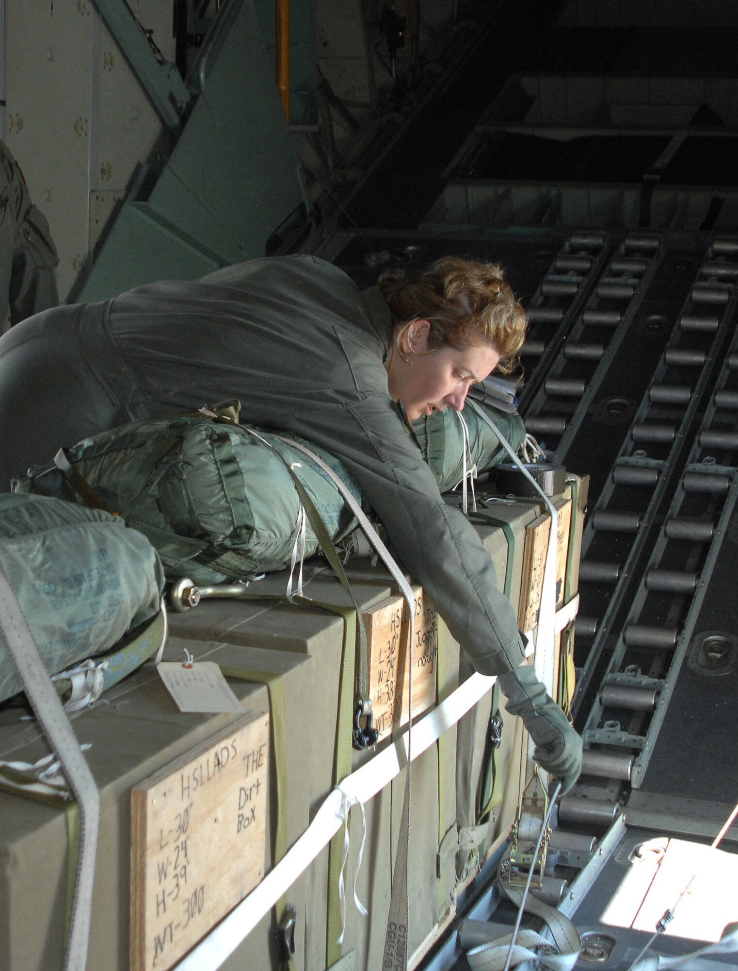 CANNON AIR FORCE BASE N.M.-- Aboard the MC-130W Combat Spear Sept 24, Tech. Sgt. Jennifer Seibt, a 73rd special Operations Squadron loadmaster, secures a communication line to prevent entanglement. Sergeant Seibt was training on a High-Speed-Low-Level Aerial Delivery System that allows Airmen to resupply ground forces if an airfield is not available. (U.S. Air Force photo by Airman Maynelinne De La Cruz)  