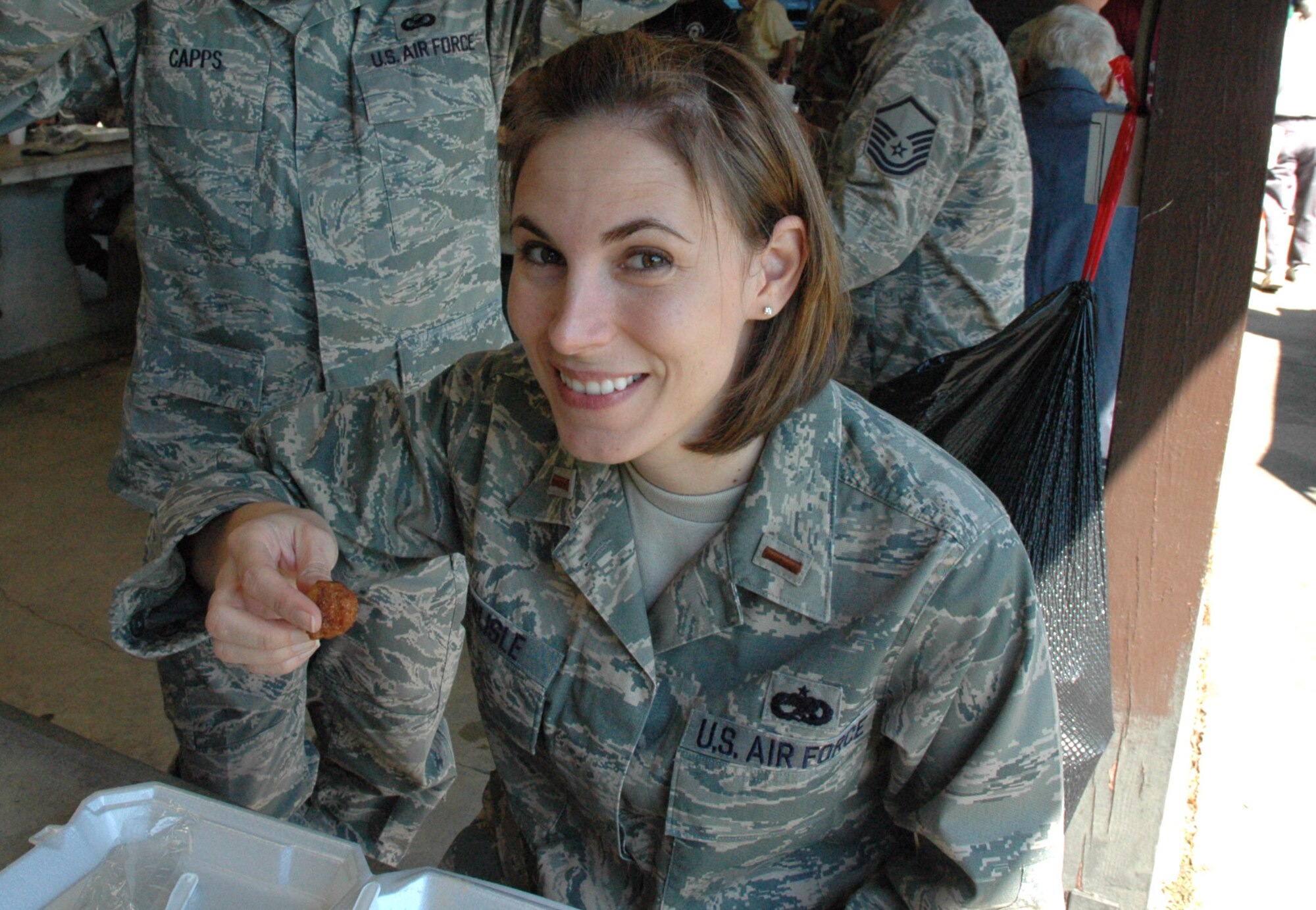 315th Operations Group Executive Officer Holly Carlisle enjoys some hushpuppies during the Charleston Chief's Group fish-fryheld here today.  The Charleston Chief's Group has had a cookout fundraiser twice a year for the last 24-years.  Money raised from the event will be distributed back to Team Charleston's airmen through programs that the Chief's Group supports.