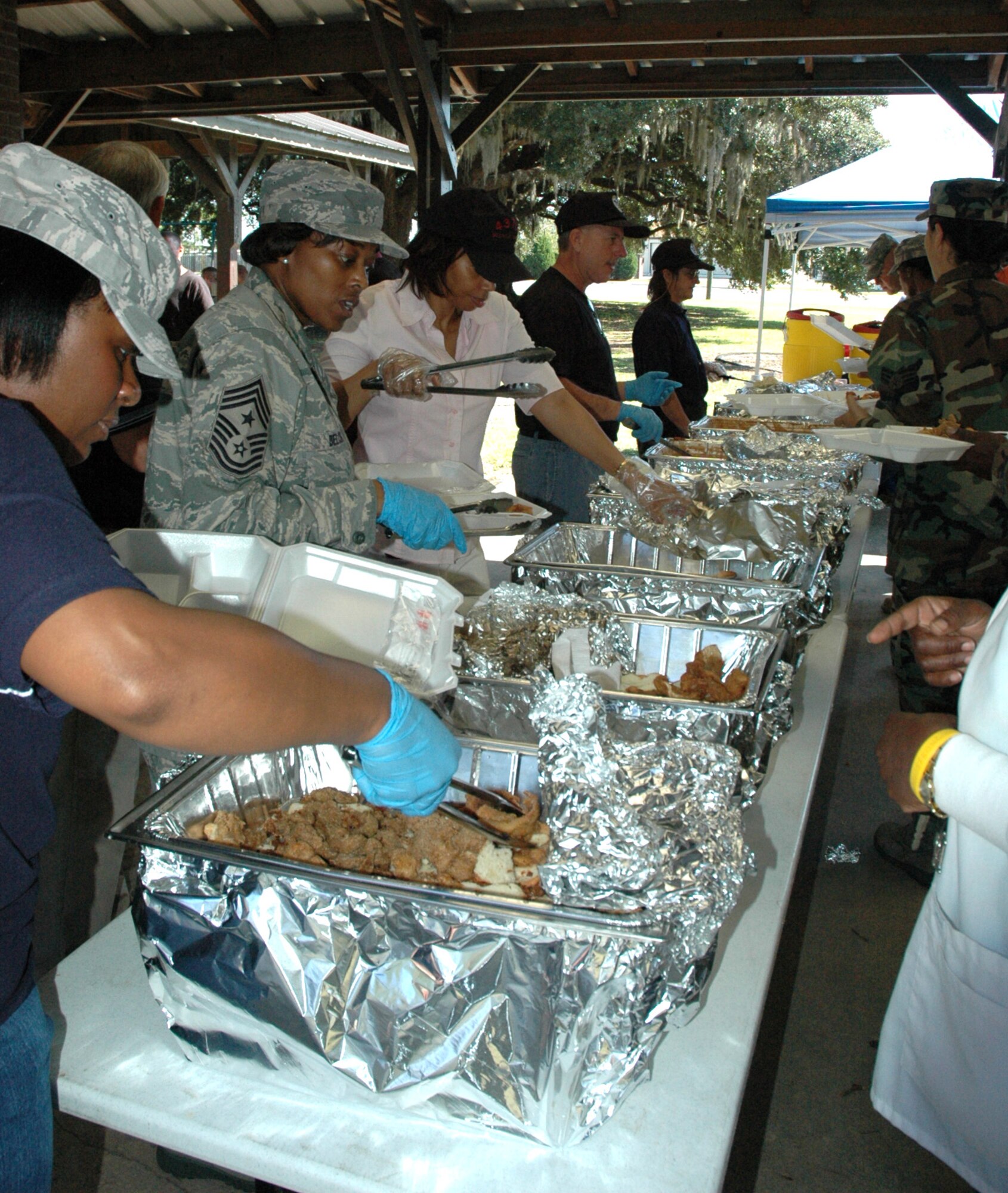 437th Airlift Wing Command Chief Master Sergeant Bernise Belcer and fellow Chiefs from Team Charleston serve food during the Charleston Chief's Group fish-fryheld here today.  The Charleston Chief's Group has had a cookout fundraiser twice a year for the last 24-years.  Money raised from the event will be distributed back to Team Charleston's airmen through programs that the Chief's Group supports.