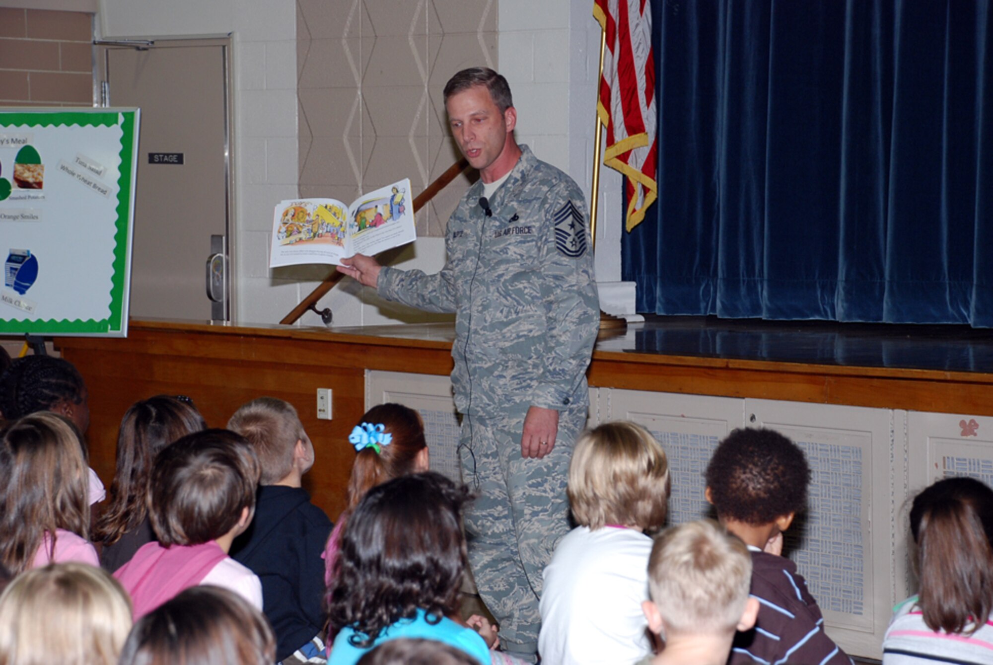 Chief Master Sgt. John Gillette, 305th Air Mobility Wing command chief reads to 100 first graders at Atlantis School Oct. 2. Chief Gillette and the children participated in Jumpstart’s Read for the Record Campaign. Adults and children around the world, including military installations, joined together to read a book for the largest shared reading experience ever. (U.S. Air Force photo/Airman 1st Class Bekah Phy)