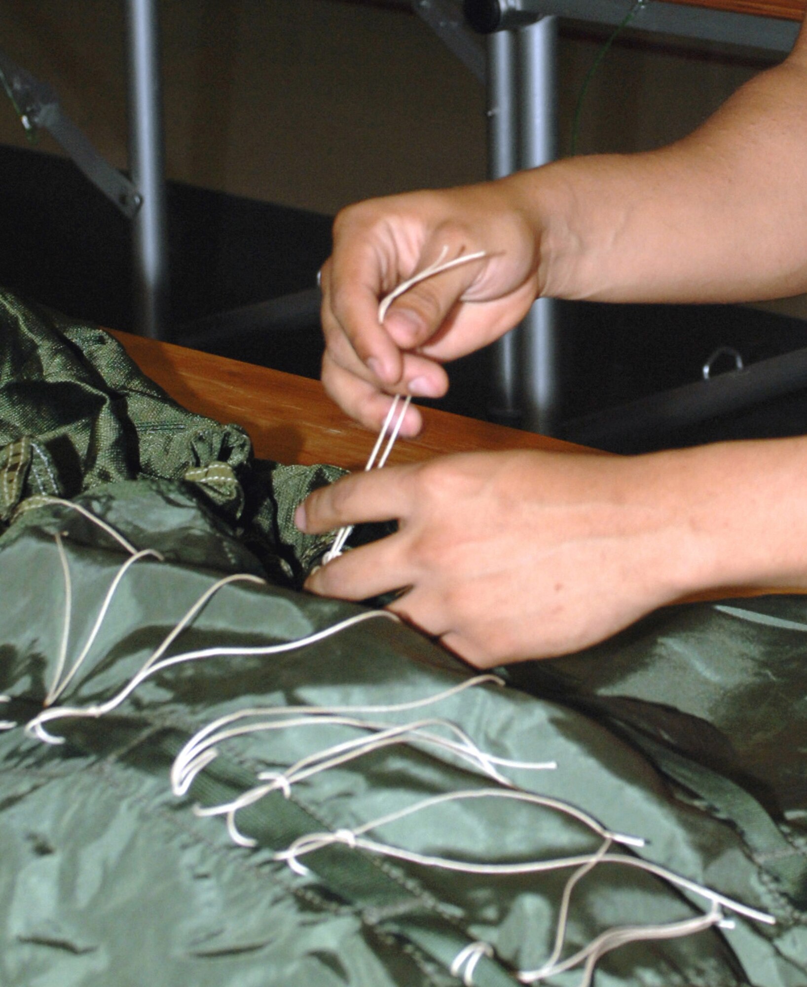 CANNON AIR FORCE BASE, N.M. - - Airman 1st Class Raul Hernandez, 27th Special Operations Logistics Readiness Squadron, applies tension to and squares the lines on a 22-foot extraction chute. Aerial delivery training is performed at least weekly at Cannon. It prepares the aircrew for resupply missions for special operations forces when an airfield cannot be used. (U.S. Air Force photo/Airman 1st Class Danielle Martin)