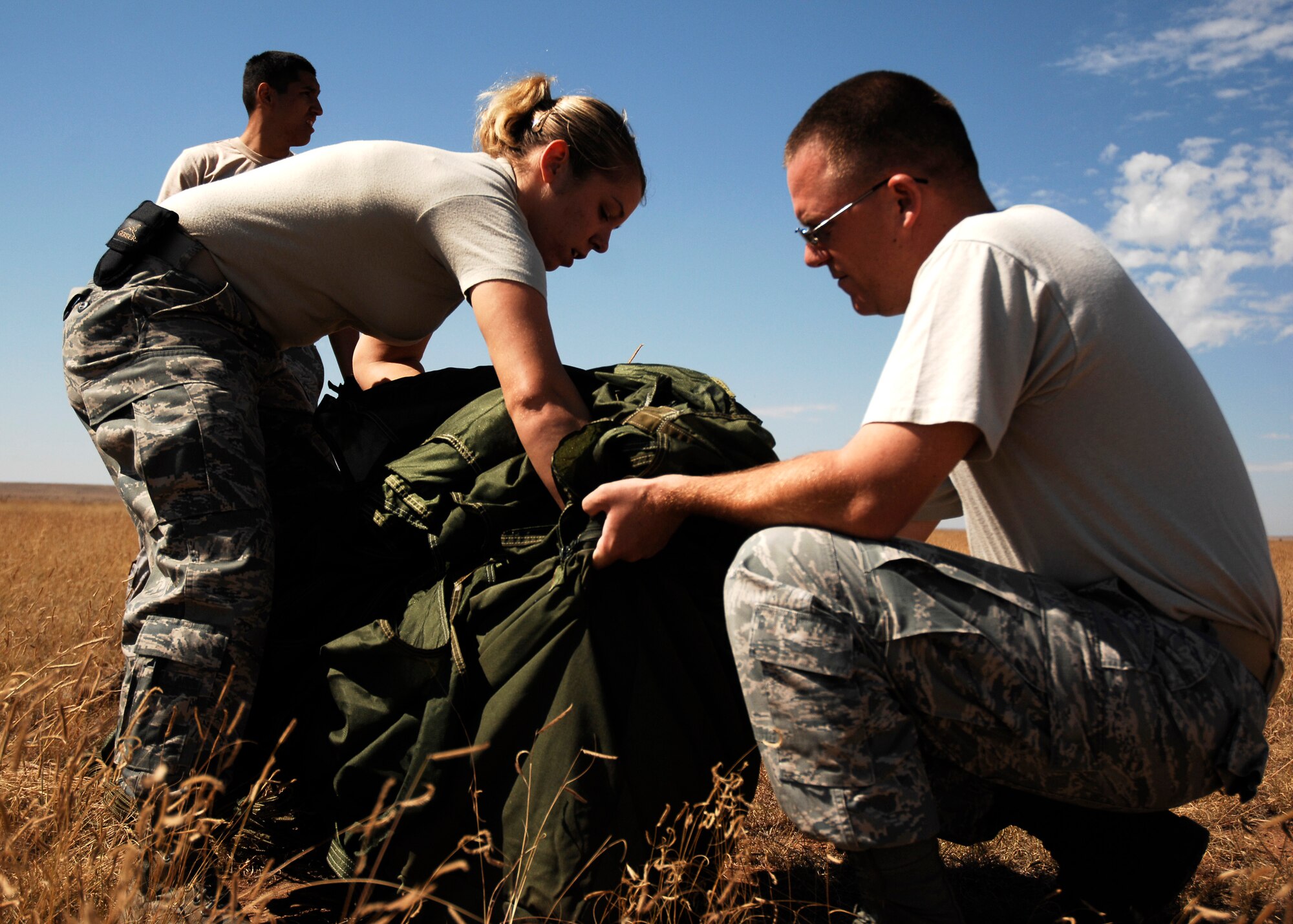 CANNON AIR FORCE BASE, N.M.-- Senior Airman Helen Eberly and Staff Sgt. Jerimy Pickering, 27th Special Operations Logistics Readiness Squadron, recover a parachute at the Melrose Air Force Range during an exercise Sept. 23. Airmen pack, inspect, and recover the loads that are used for airdrop training. (U.S. Air Force photo/Airman 1st Class Evelyn Chavez) 