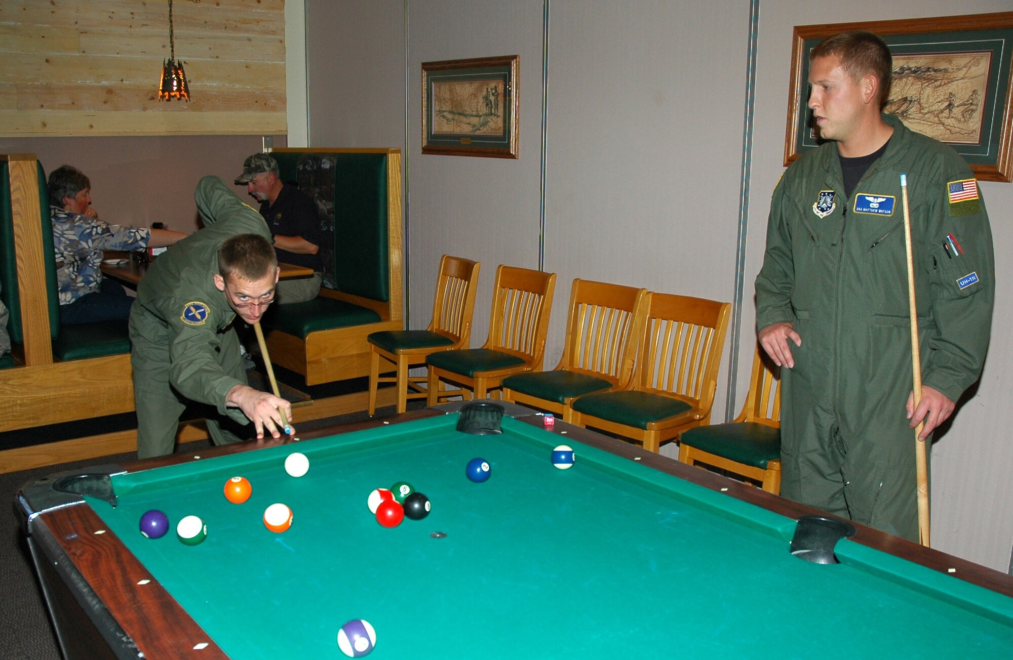 Senior Airman Michael Frank, 40th Helicopter Squadron flight engineer, and Senior Airman Matthew Watson, 40th HS flight engineer, play pool in the Minuteman Lounge of the Graizzly Bend Club during its grand reopening Sept. 26. New additions to the club include a foosball table, three new 52 inch televisions coupled with electronic versions of Texas hold'em and trivia that are playable against patrons of other Air Force clubs, a new smoking patio and new menu items from JR Rockers. (U.S. Air Force photo/Airman 1st Class Dillon White)