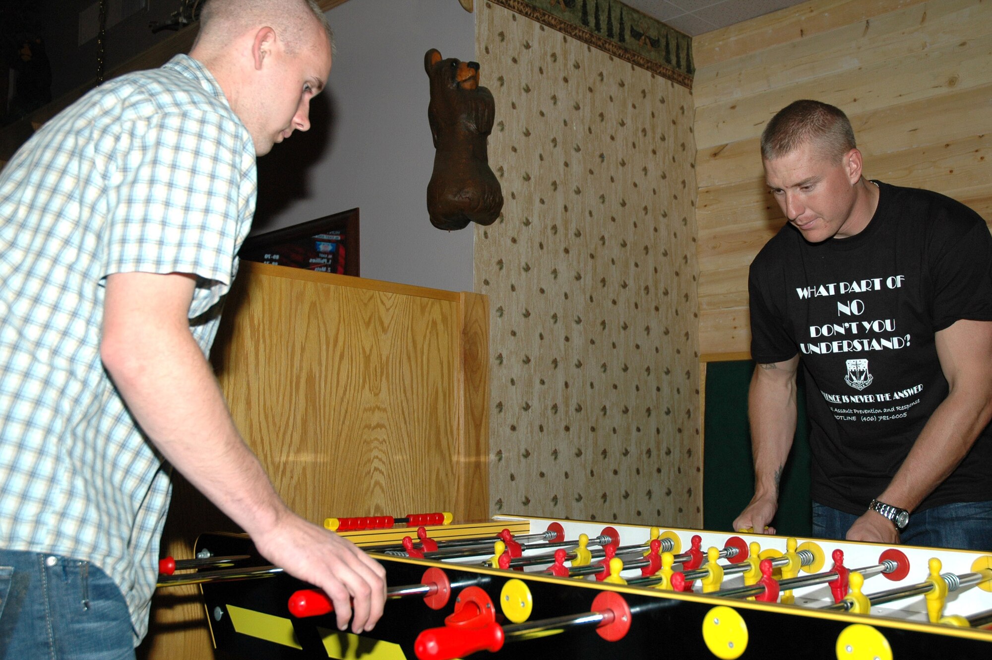 Airman 1st Class Josh Ramsted, 341st Security Forces Squadron member, and Airman 1st Class Eric Houghton, 341st Missile Maintenance Squadron periodic maintenance member, play foosball during the grand reopening of the Grizzly Bend Club Sept. 26. The foosball table is a new addition to the club, as well as three new 52 inch televisions coupled with electronic versions of Texas hold'em and trivia playable against patrons of other Air Force clubs, a new smoking patio and new menu items from JR Rockers. (U.S. Air Force photo/Airman 1st Class Dillon White)