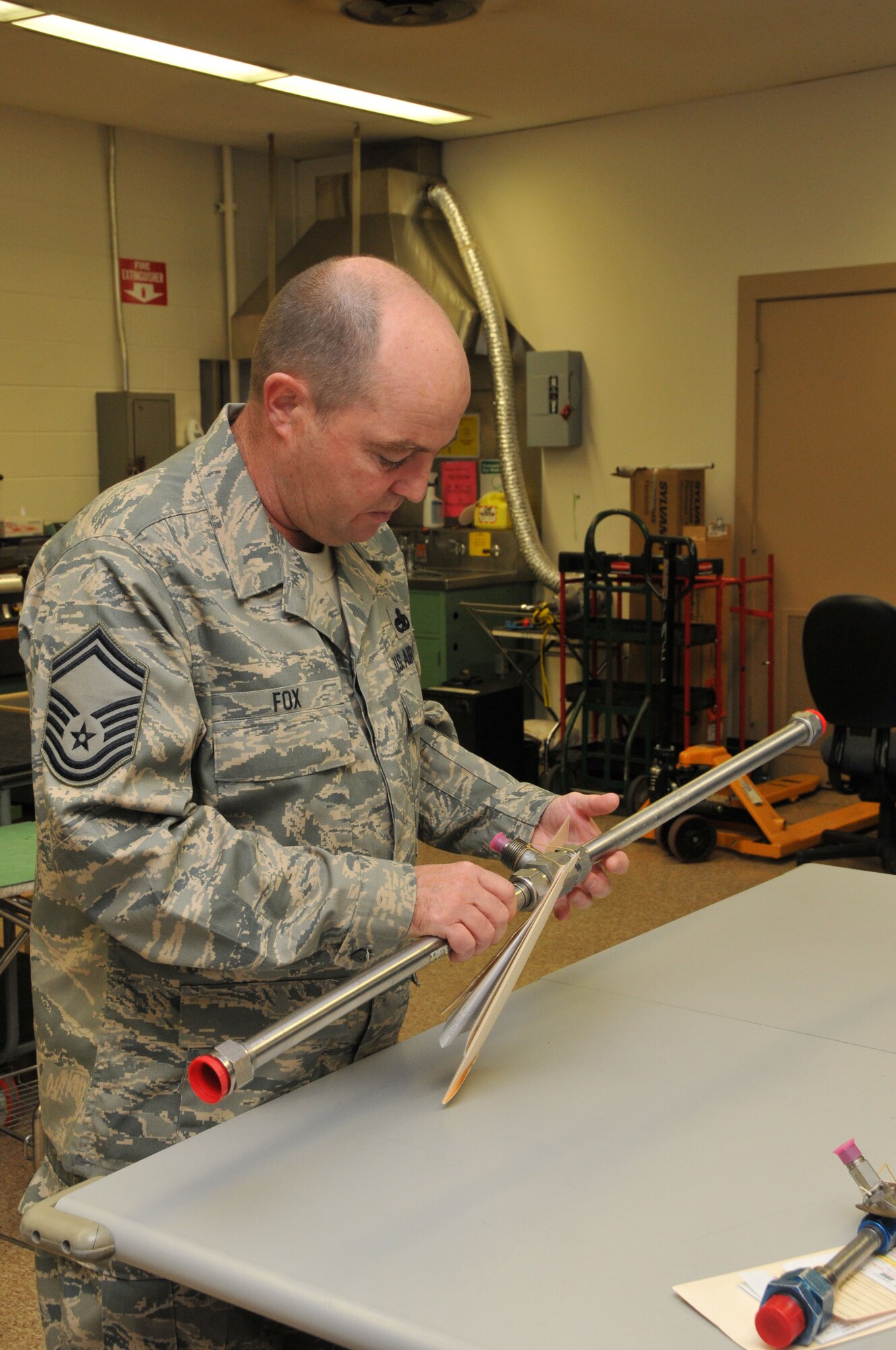 Senior Master Sgt. Martin Fox, the Test, Measurement and Diagnostic Equipment Superintendant at Holloman Air Force Base, inspects a flow meter calibrated at Arnold Engineering Development Center’s PMEL. (Photo by David Housch)