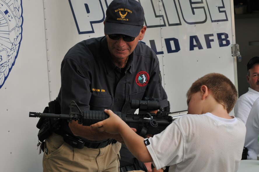 In celebration of the Air Force’s 61st birthday, AEDC hosted a birthday bash to commemorate the milestone. Activities and demonstrations of all types were part of this year’s event. Above, Kevin Syler, Arnold AFB installation security officer with the AEDC Police Department, takes the opportunity to explain his role in the Air Force’s mission to a child attending the Birthday Bash. (Photo by David Housch)