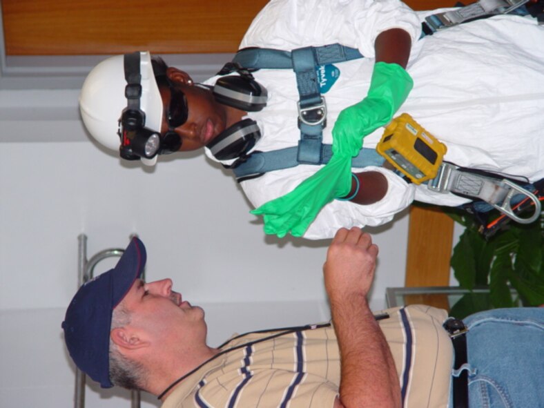 A student puts on safety gloves during a industrial hygiene demonstration in the Main Auditorium Lobby. (Photo by Joel Fortner) 