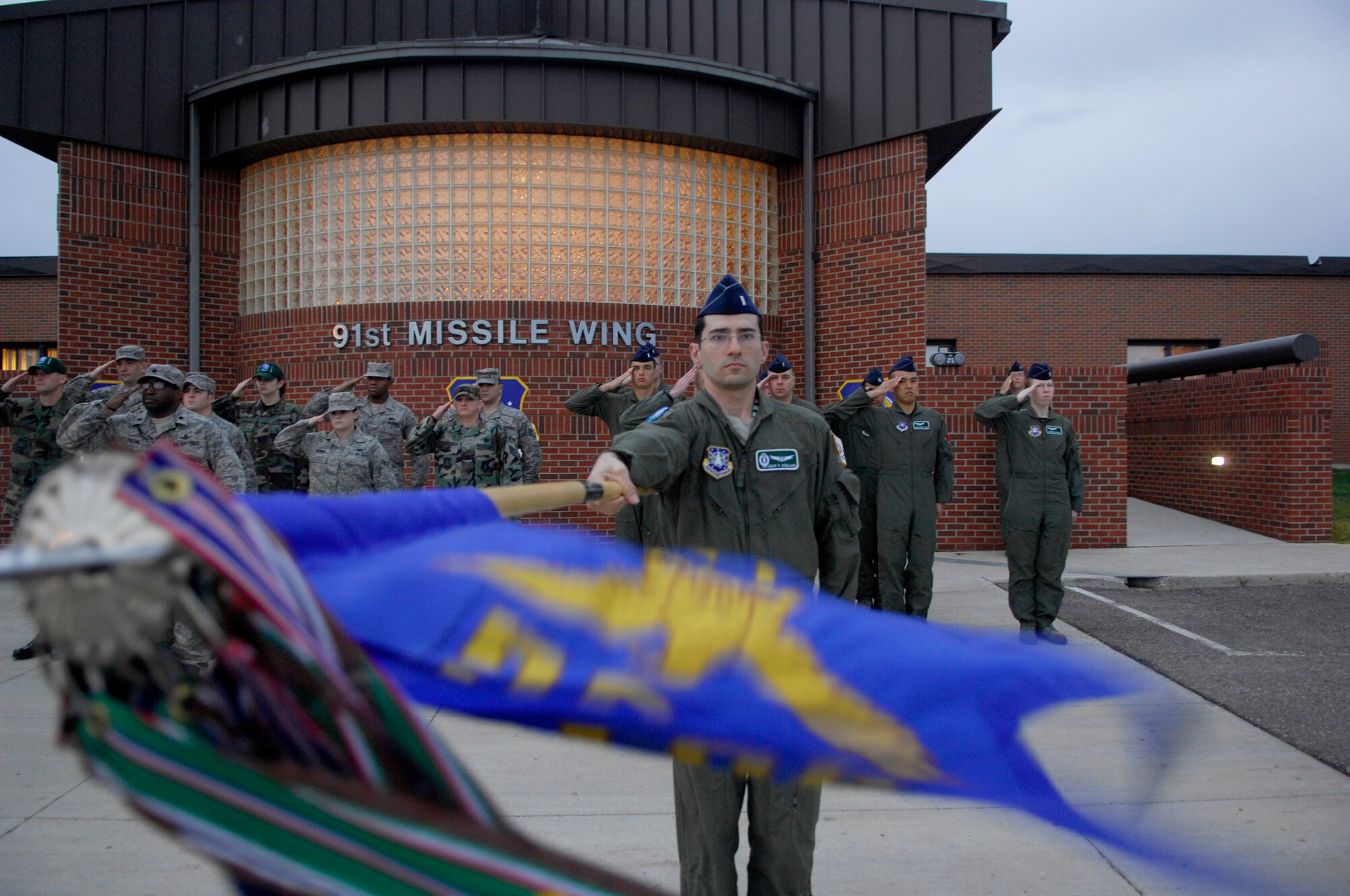 MINOT AIR FORCE BASE, N.D. -- 1st Lt. Adam Howland, intercontinental ballistic missile combat crew deputy commander, presents the 791st Missile Squadron’s guidon during a reveille ceremony held here, Sept. 26. The squadrons in the 91st Missile Wing periodically rotate the honor of performing reveille ceremonies throughout the year. (U.S. Air Force photo by Senior Airman Joe Rivera)