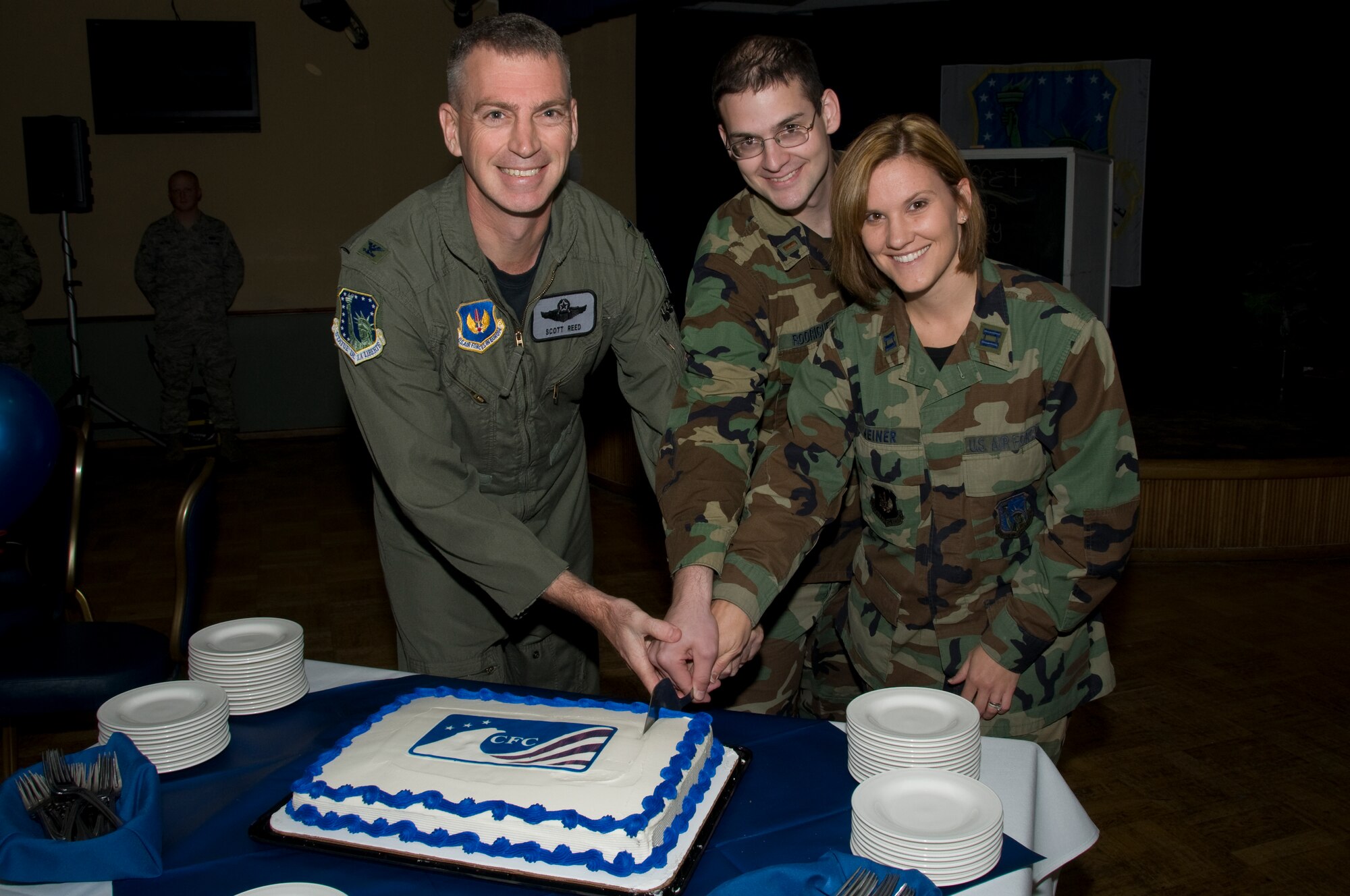 Col. Scott Reed, 48th Fighter Wing vice commander, Capt. Jana Weiner, 48th Medical Operations Squadron and 2nd Lt. Alan Rodriguez, 48th Comptroller Squadron cut the cake marking the start of the CFC campaing Oct. 3 at RAF Lakenheath, England. (U.S. Air Force photo by Airman 1st Class Perry Aston)