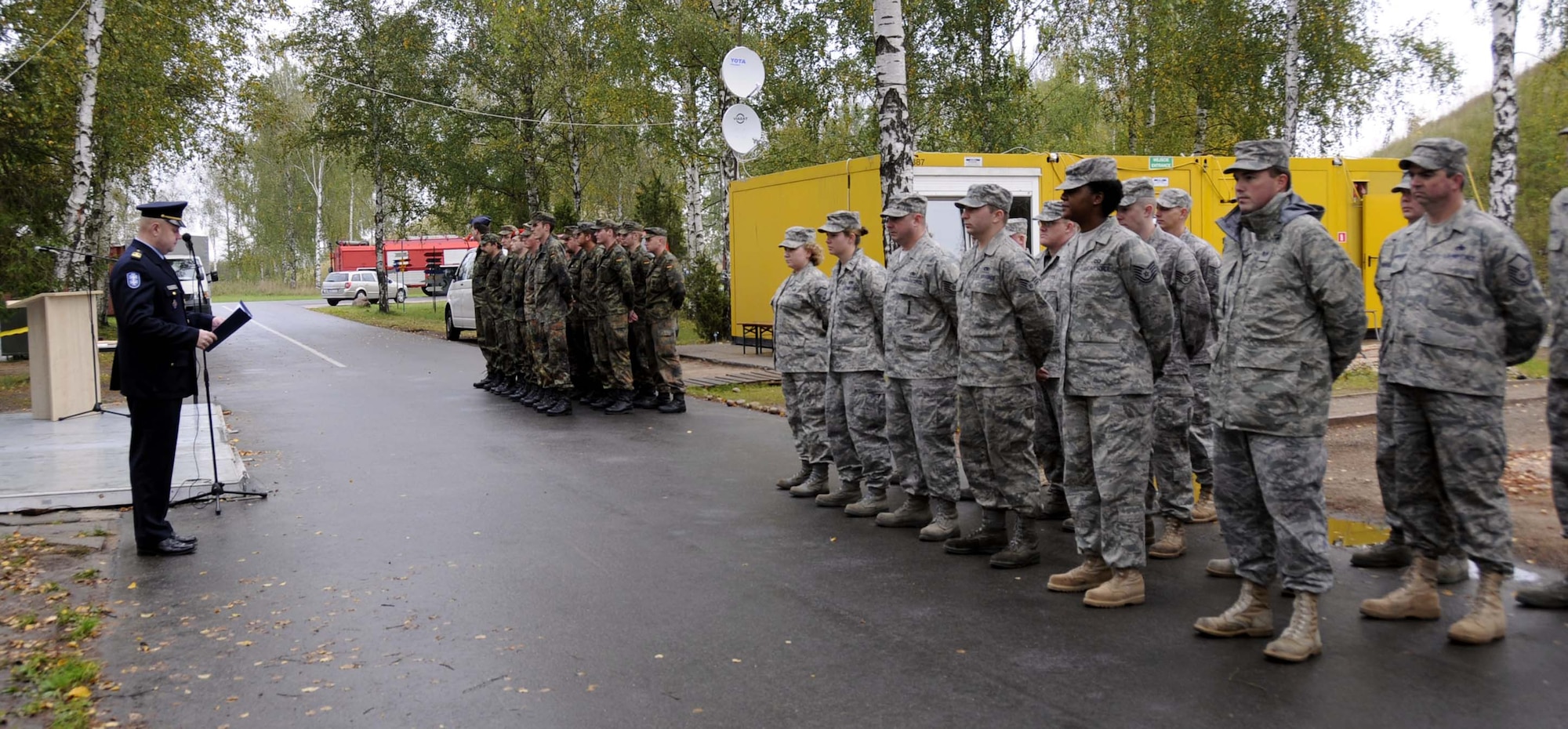 Lithuanian SWO Alvydas Tamosiunas welcomes everyone to the change-over ceremony as the U.S. and German formations wait for the beginning of the ceremony marking the first day of the U.S. rotation performing the NATO Baltic air policing mission. (U.S. Air Force photo by Tech. Sgt. Jill Lavoie)