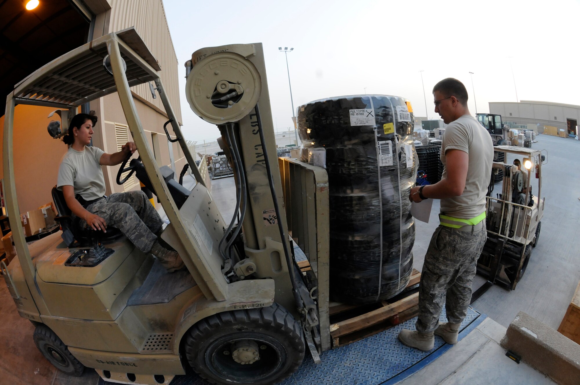 Staff Sgt. Marveline Engle uses a forklift to place received items onto the end of the ramp while Airman 1st Class Tyler Sexton inventories the items and writes the receiving unit and Airman 1st Class Frank Maguina waits in another forklift to take the items into the storage yard Oct. 2, 2008, at an undisclosed air base in Southwest Asia. All three are traffic management specialists assigned to the 379th Expeditionary Logistics Readiness Squadron, responsible for getting mission essential parts into the area of responsibility. Sergeant Engle, a native of Houston, Texas, is deployed from Bolling Air Force Base, District of Columbia.  Airman Sexton, a native of Columbia, Ohio, is deployed from Royal Air Force Mildenhall, United Kingdom, and Airman Maguina, a native of Long Island, N.Y., is deployed from Langley Air Force Base, Va.  All are deployed in support of Operations Iraqi and Enduring Freedom and Joint Task Force-Horn of Africa. (U.S. Air Force photo by Staff Sgt. Darnell T. Cannady/Released)