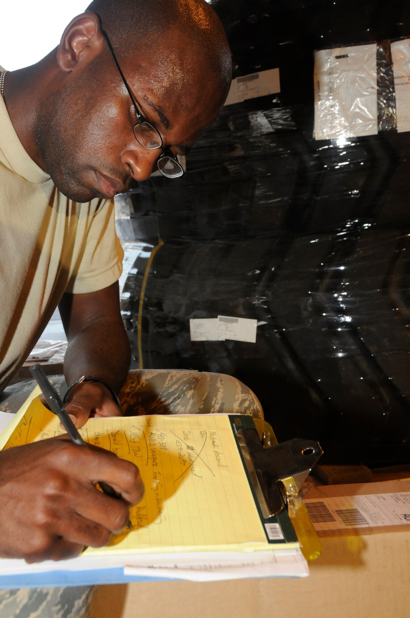 Airman 1st Class Darrell Lewis, traffic management apprentice assigned to the 379th Expeditionary Logistics Readiness Squadron, writes down tracking numbers and customer information for parts received Oct. 2, 2008, at an undisclosed air base in Southwest Asia. Traffic managers are responsible for getting mission essential parts into the area of responsibility. Airman Lewis, a native of Milwaukee, Wis., is deployed from Scott Air Force Base, Ill., in support of Operations Iraqi and Enduring Freedom and Joint Task Force-Horn of Africa. (U.S. Air Force photo by Staff Sgt. Darnell T. Cannady/Released)