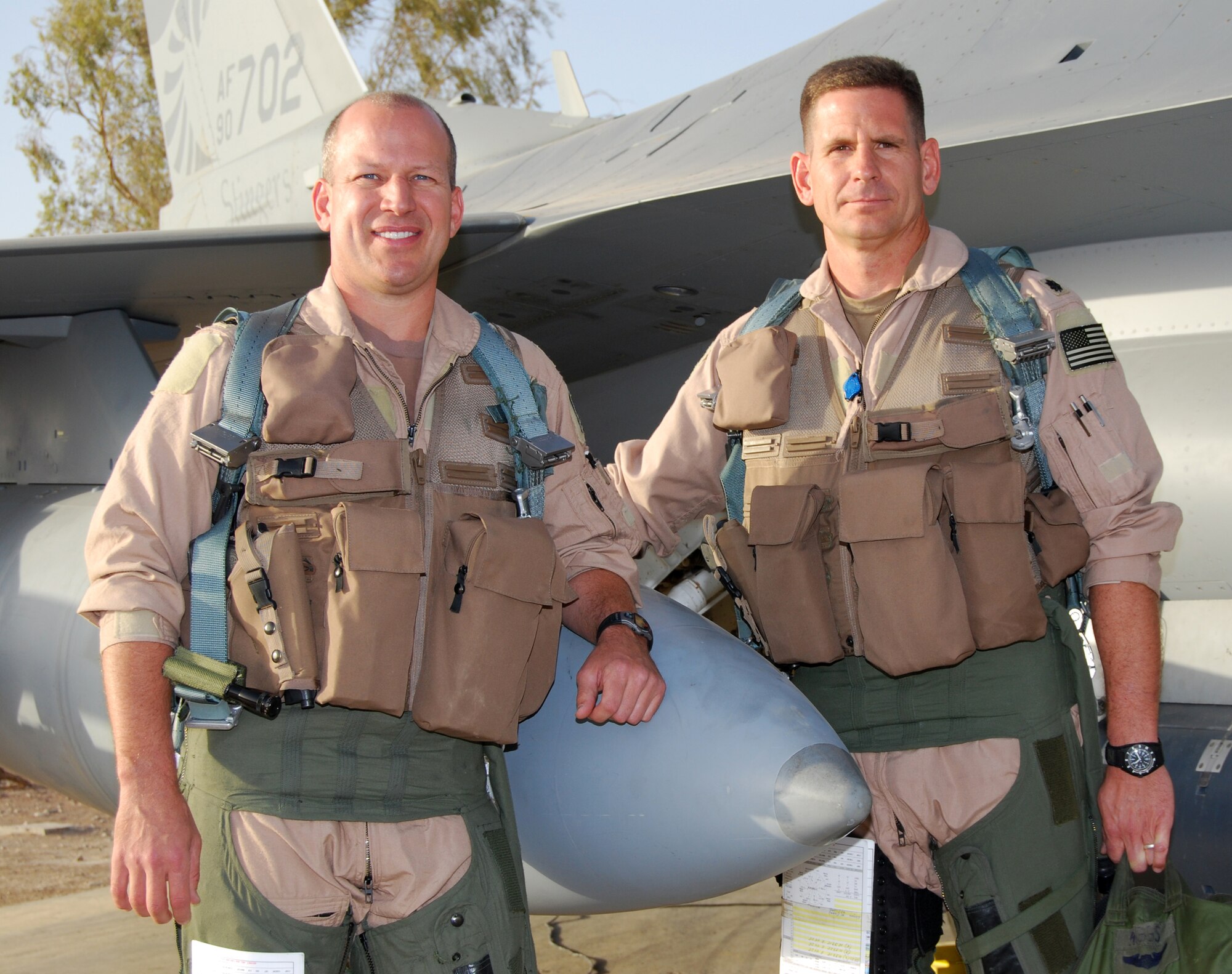 Lt. Cols. David Serage and Todd Higgs pose for a photograph in front of Serage's F-16 Fighting Falcon at Joint Base Balad, Iraq, Oct. 2. Serage, an instructor pilot with the 332nd Expeditionary Fighter Squadron, flew his 100th combat sortie, and Higgs flew as his wingman. The colonels are deployed from the Air National Guard's 138th Fighter Wing in Tulsa, Okla. (U.S. Air Force photo/Staff Sgt. Don Branum)