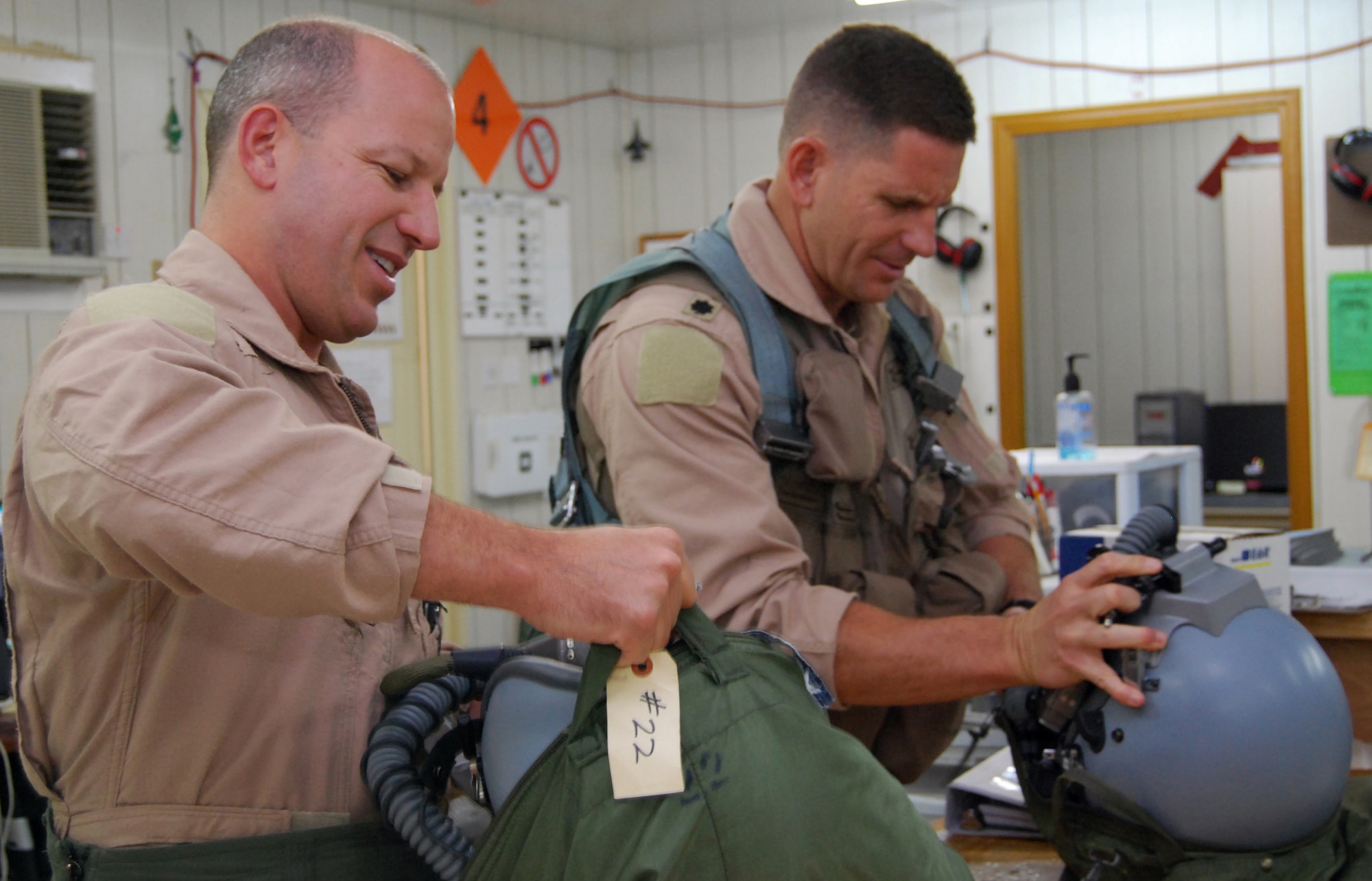 Lt. Cols. David Serage and Todd Higgs prepare their life support equipment at Joint Base Balad, Iraq, for a mission Oct. 2. Serage, an instructor pilot with the 332nd Expeditionary Fighter Squadron, flew his 100th combat sortie, and Higgs flew as his wingman. The colonels are deployed from the Air National Guard's 138th Fighter Wing in Tulsa, Okla. (U.S. Air Force photo/Staff Sgt. Don Branum)