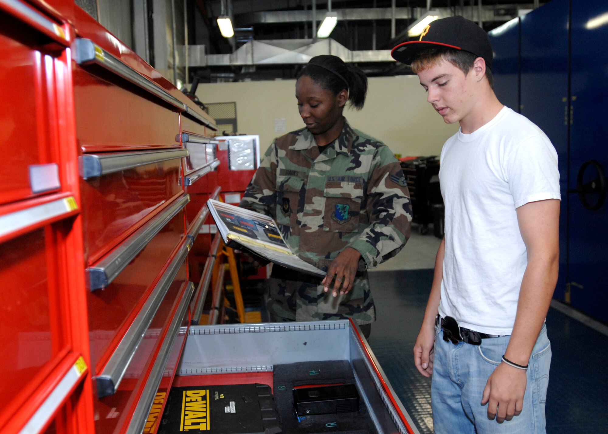 Airman 1st Class Tasheika Starks of the 31st Logistics Readiness Squadron and Aviano High School student Thomas Watson organize tools within the vehicle maintenance shop. Thomas is interning with the 31st LRS as part of the Aviano High School career practicum course, which affords students the opportunity to intern with base units that feature the student's career field of interest. (U.S. Air Force photo/Airman 1st Class Ashley Wood)