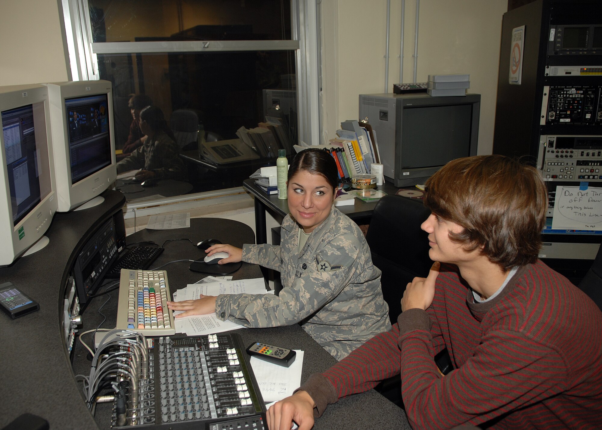Airman Lauren Lagudi of Armed Forces Network Detachment 8 instructs Aviano High School senior Tyler Leahy on some of the video equipment the detachment uses to produce its products. Tyler is interning with AFN as part of the Aviano High School career practicum course, which affords students the opportunity to intern with base units that feature the student's career field of interest. (U.S. Air Force photo/Senior Airman Taylor Marr)
