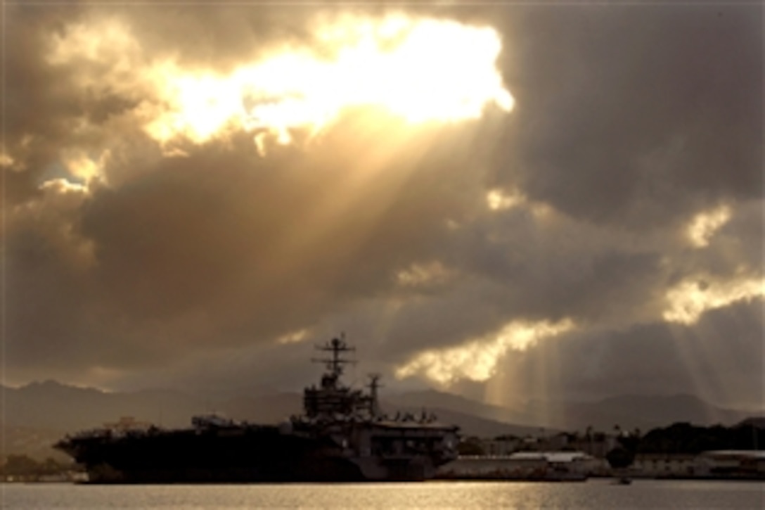 The breaks through the clouds over aircraft carrier USS Abraham Lincoln during a scheduled port visit at Pearl Harbor Naval Station, Hawaii, Oct. 1, 2008. The Abraham Lincoln Carrier Strike Group is on a scheduled deployment in the U.S. 7th Fleet area of responsibility.