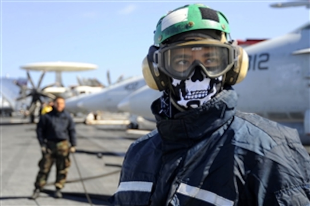 U.S. Navy Airman Yuri Fernandez looks towards the bow of the aircraft carrier USS Theodore Roosevelt to ensure there are no personnel near the catapults before flight operations, in the Atlantic Ocean, Oct. 1, 2008. Theodore Roosevelt and embarked Carrier Air Wing 8 are underway on a scheduled deployment. Fernandez is an aviation boatswain's mate.