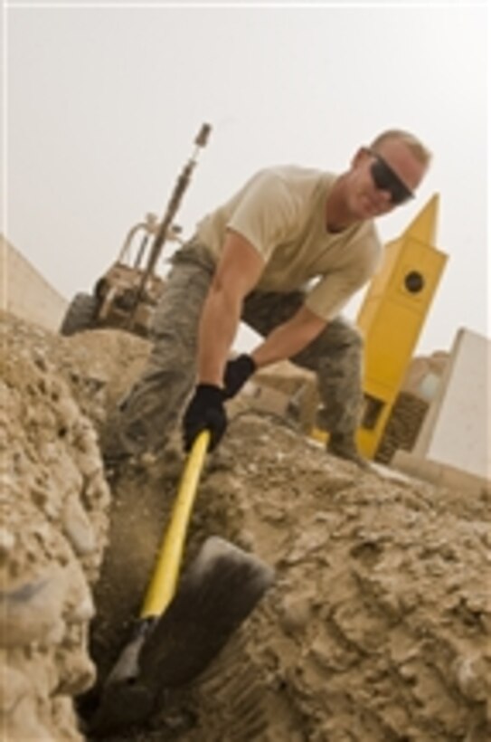 U.S. Air Force Staff Sgt. Justin Teuscher uses a pick axe to dig a trench for water and sewer lines at Ali Base, Iraq, on Oct. 1, 2008.  Teuscher is from the 407th Expeditionary Civil Engineer Squadron's utilities shop, which is laying water and sewer lines in order to leave the base better than they found it when turning the base over to Iraqi forces.  